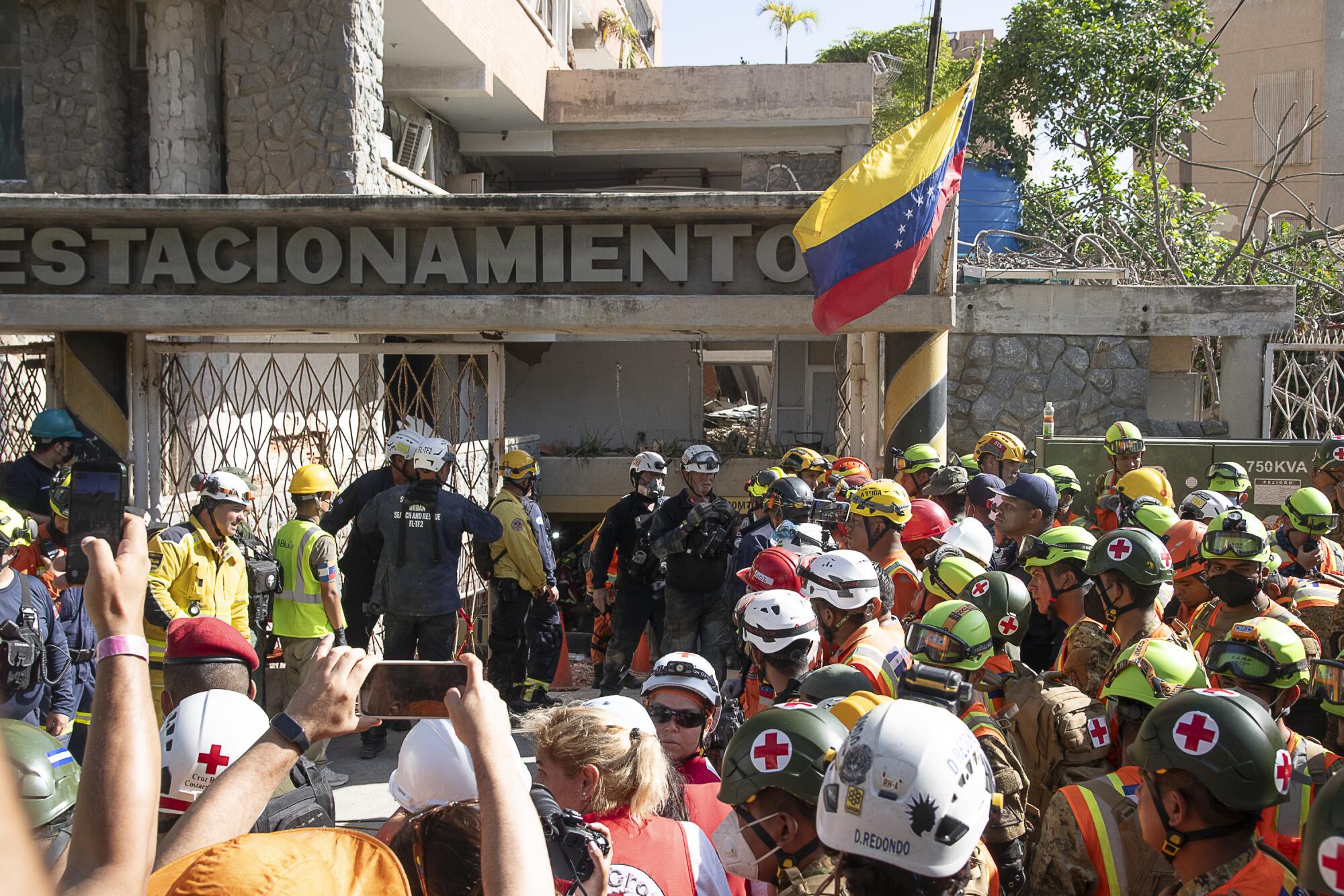 Rescuers from international delegations outside the rescue site await the exit of Hernan Gil.