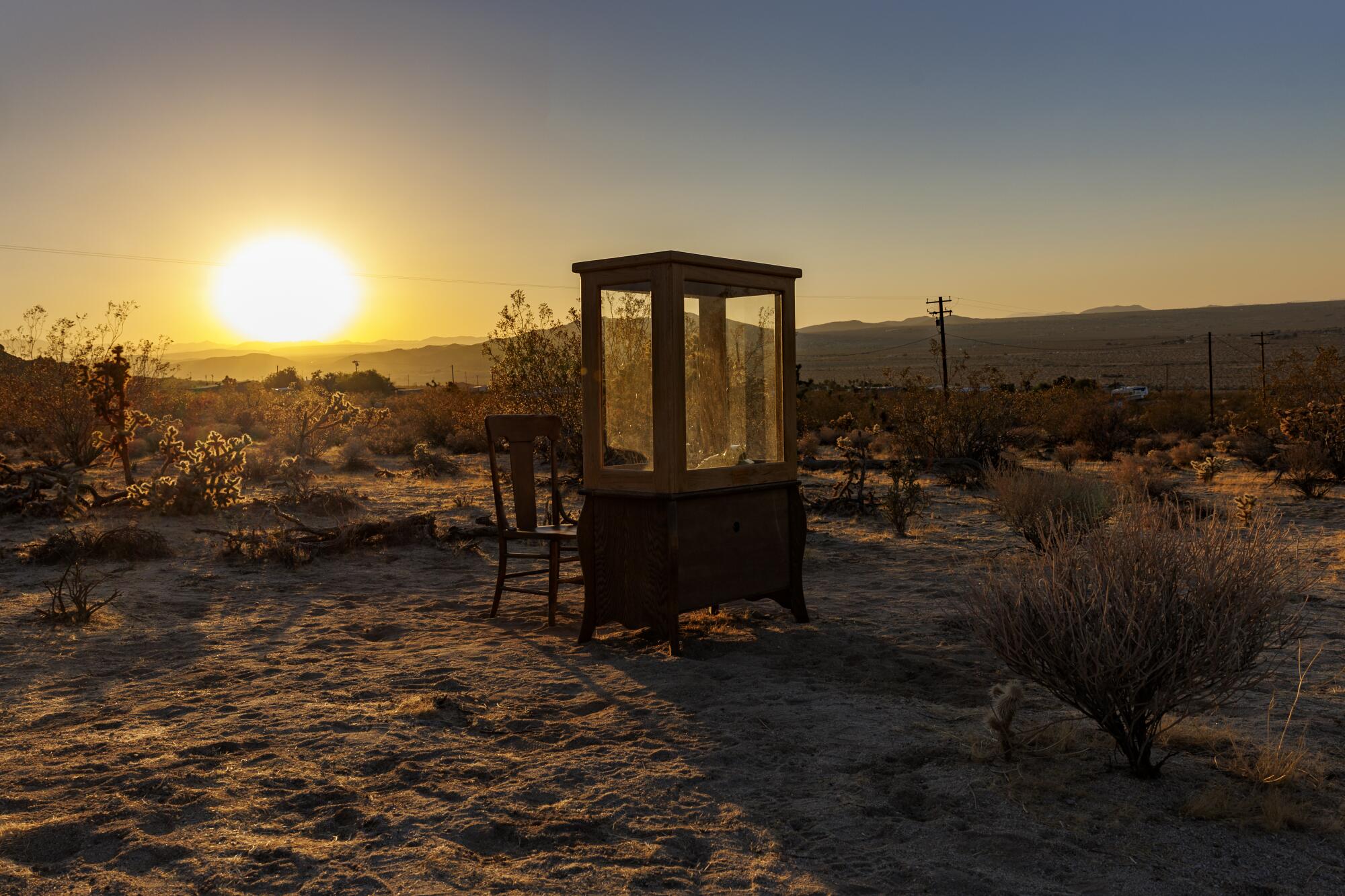 A custom phone booth in a desert setting at sunset.