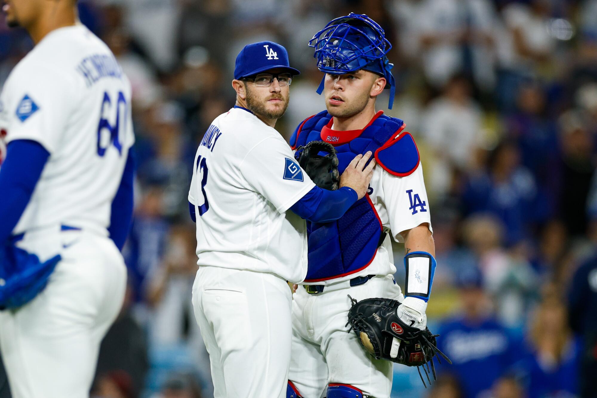 Dodgers third baseman Max Muncy holds back Dalton Rushing.