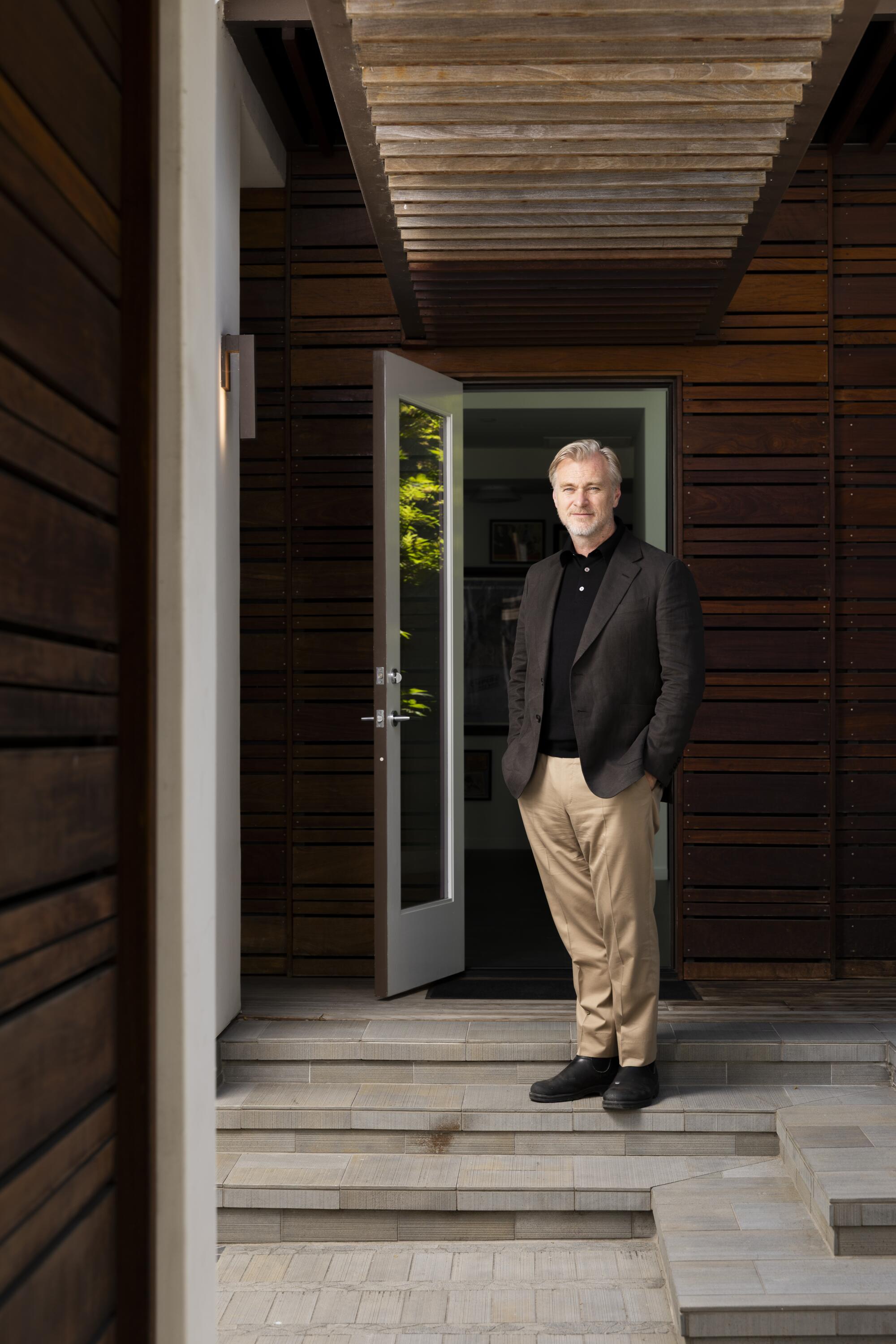 A smiling man stands in a hallway.