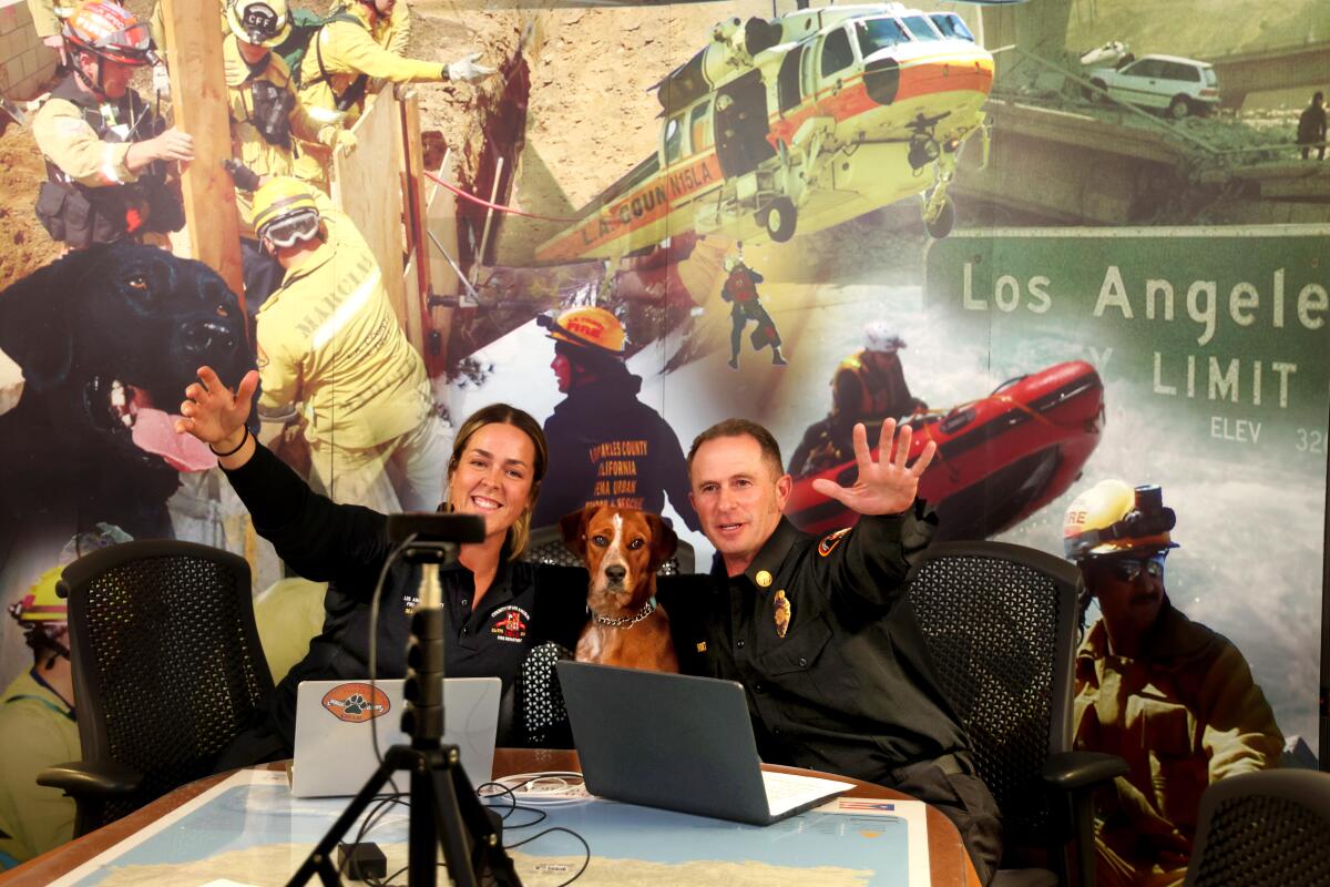 LAFD Battalion Chief Greg Short and Rebekah Drews wave goodbye to members of the Urban Search and Rescue team.