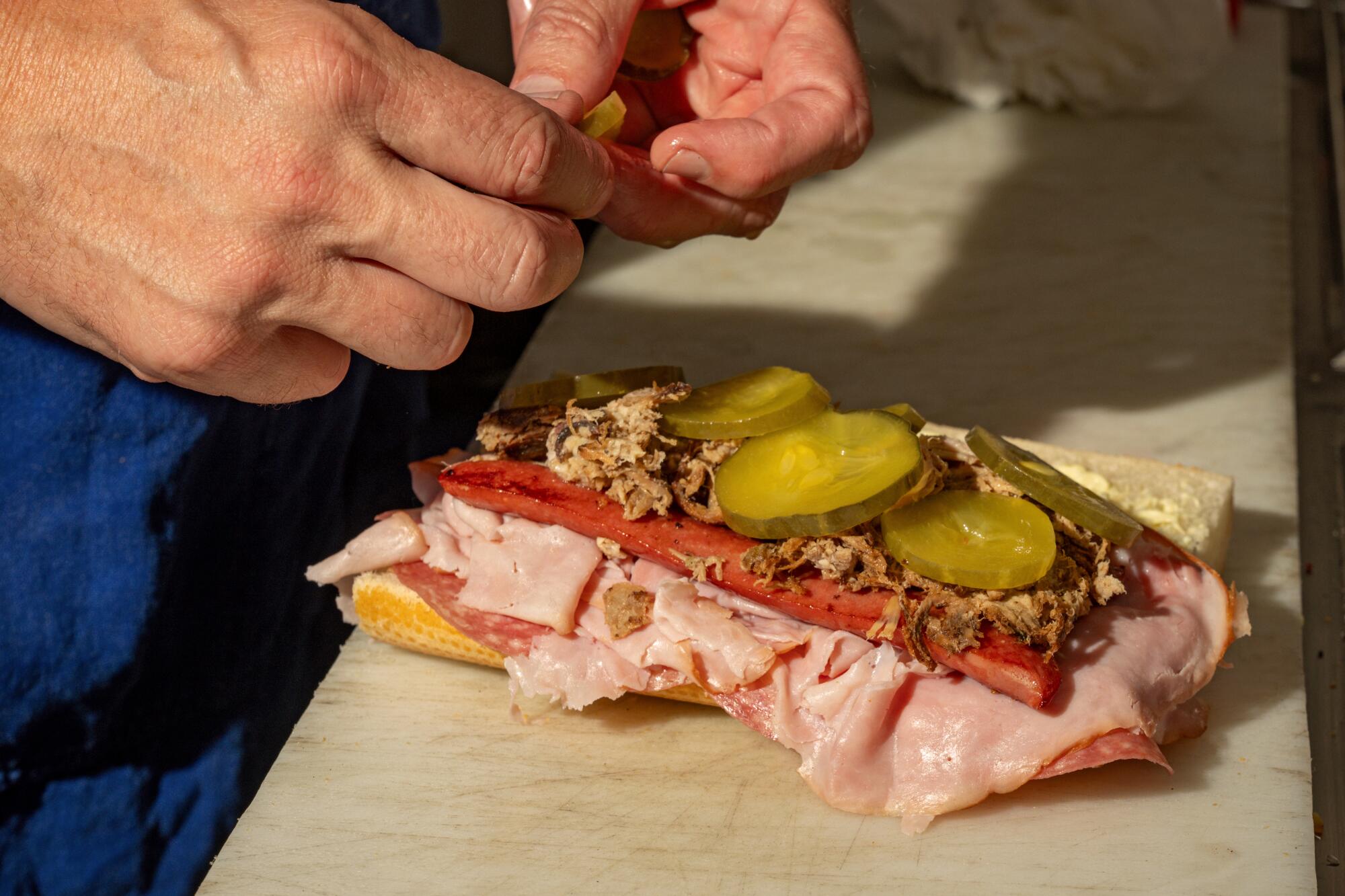 LaSorted's owner Tommy Brockert builds a Cuban Dog in the kitchen at his Chinatown location.