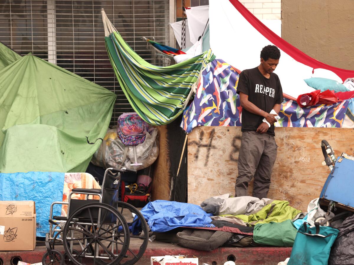 A man stands among his belongings in Skid Row.