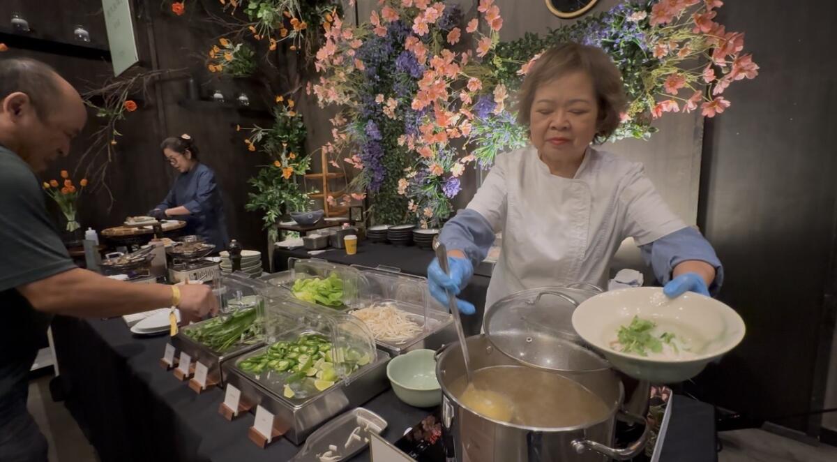 The pho station at AnQi Bistro's Bia Hoi Marketplace serves hot pho soup.