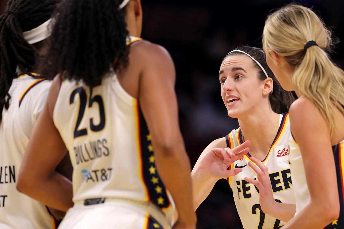 Caitlin Clark of the Indiana Fever talks with teammates during the second quarter.