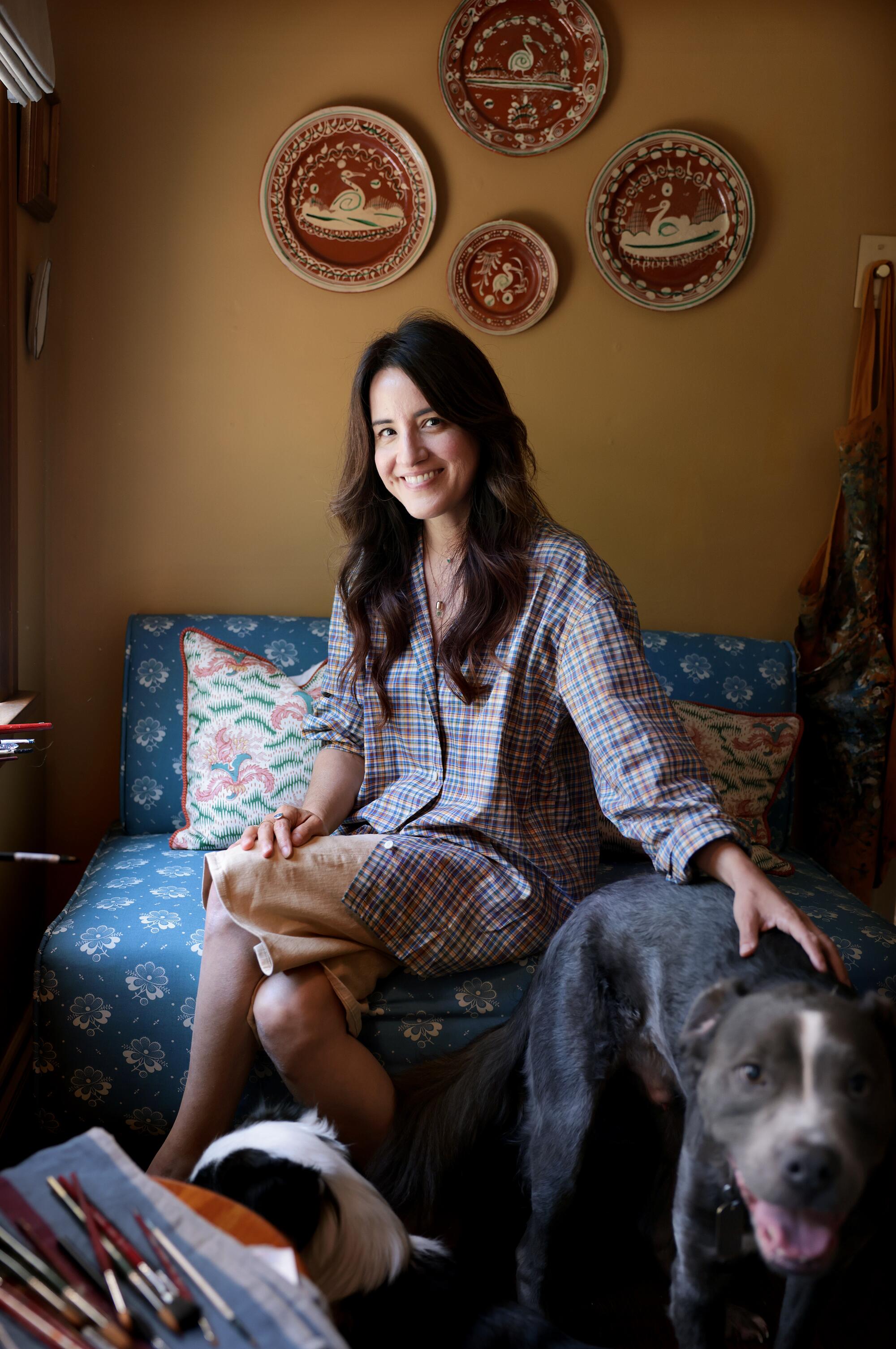 Esme Saleh sits with her dogs at home 