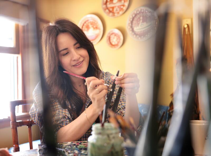 Esme Saleh paints a candle in her dining room