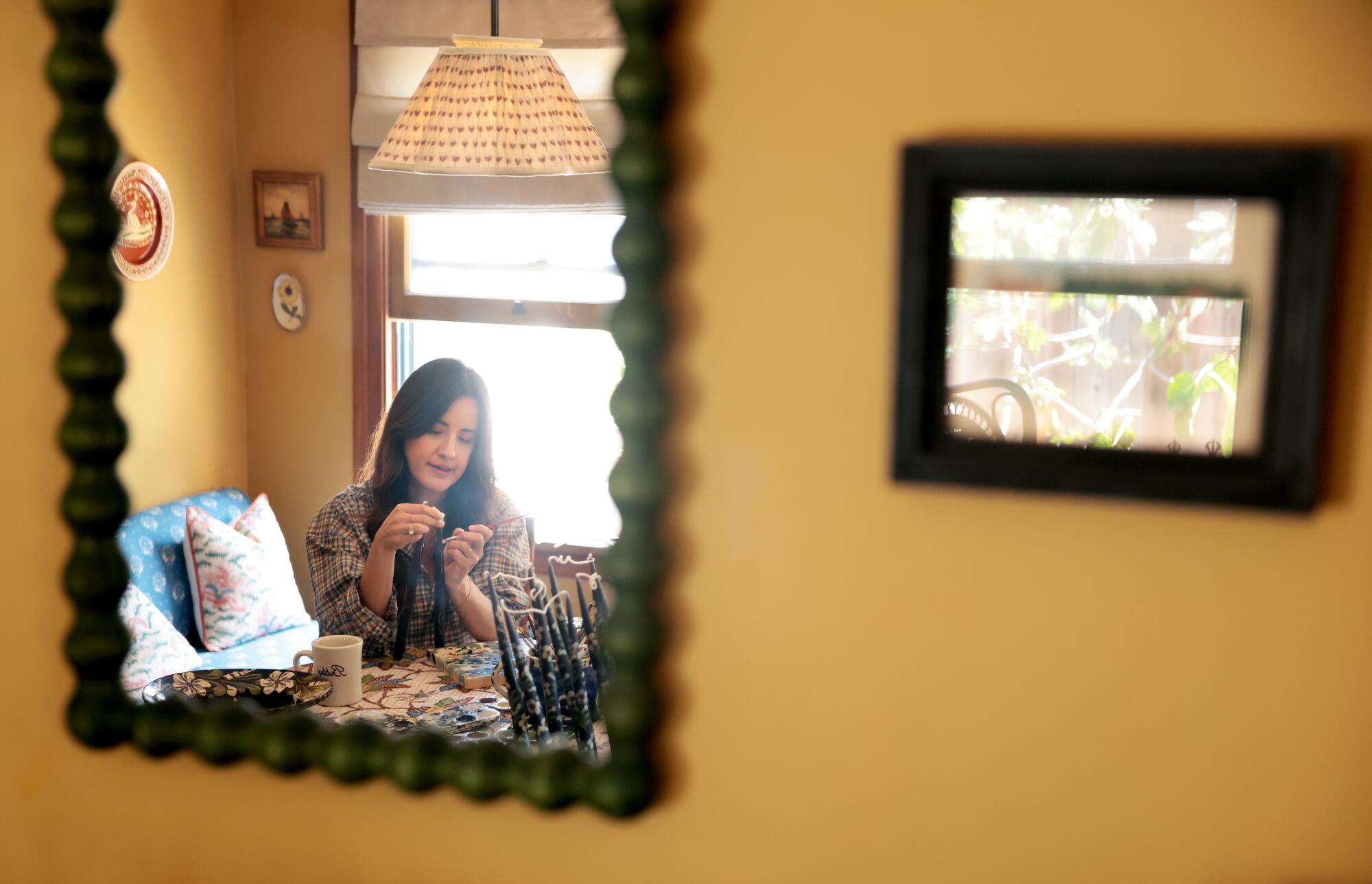 Saleh paints candles at her home.