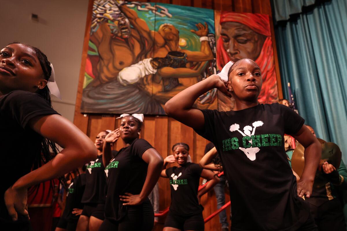 Inglewood High cheer squad members perform with the marching band.  