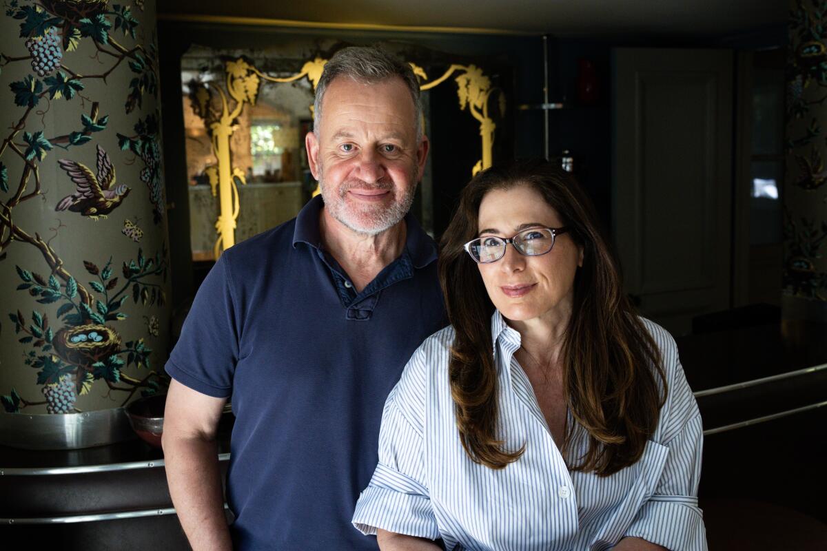 Peter and Nanci Ellis pose for a portrait in their home