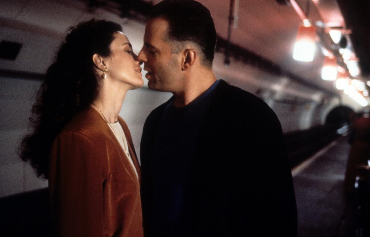 Two people kiss in the subway.