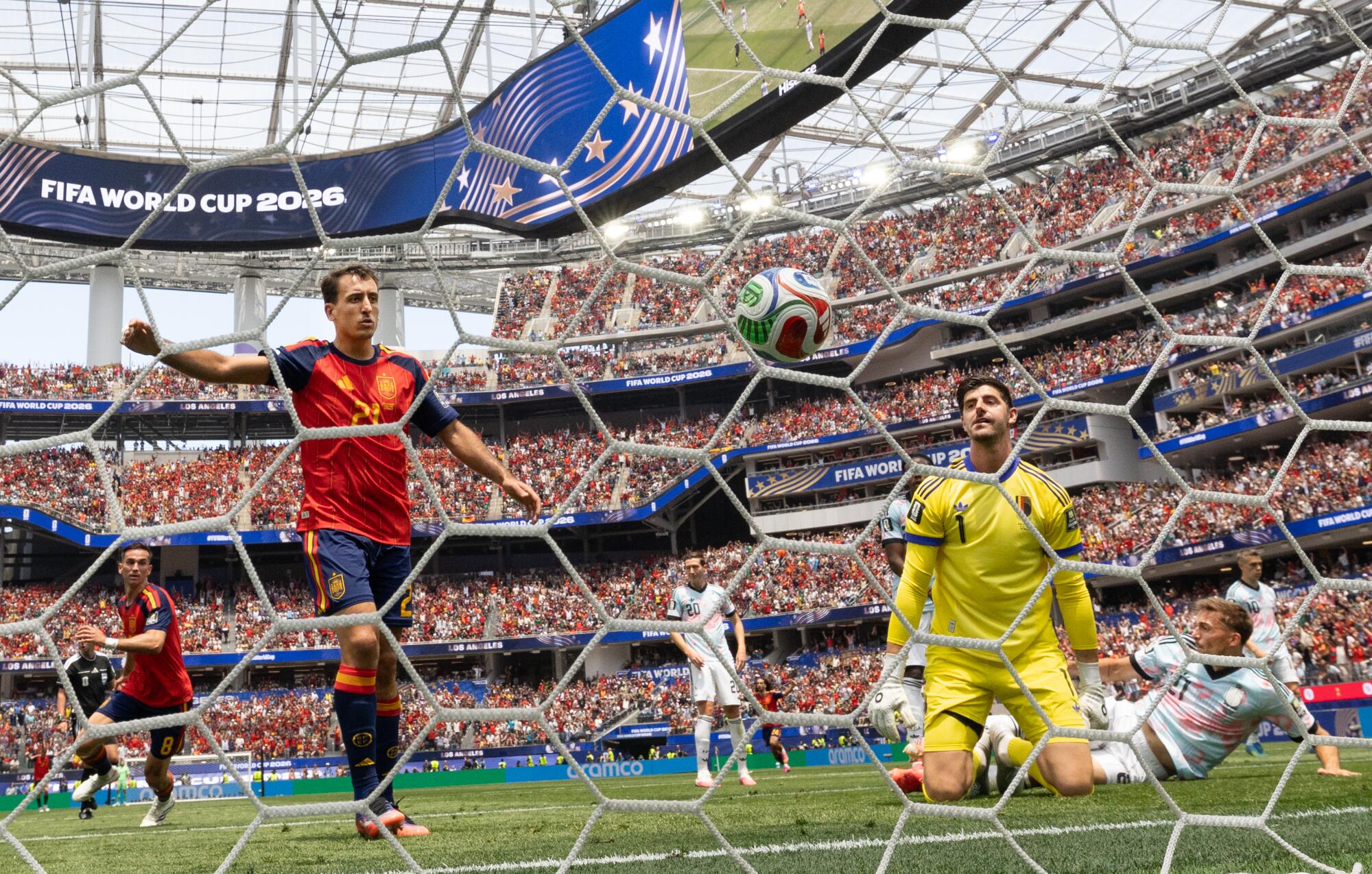 Spain midfielder Fabián Ruiz, left, celebrates after scoring past Belgium goalkeeper Thibaut Courtois.