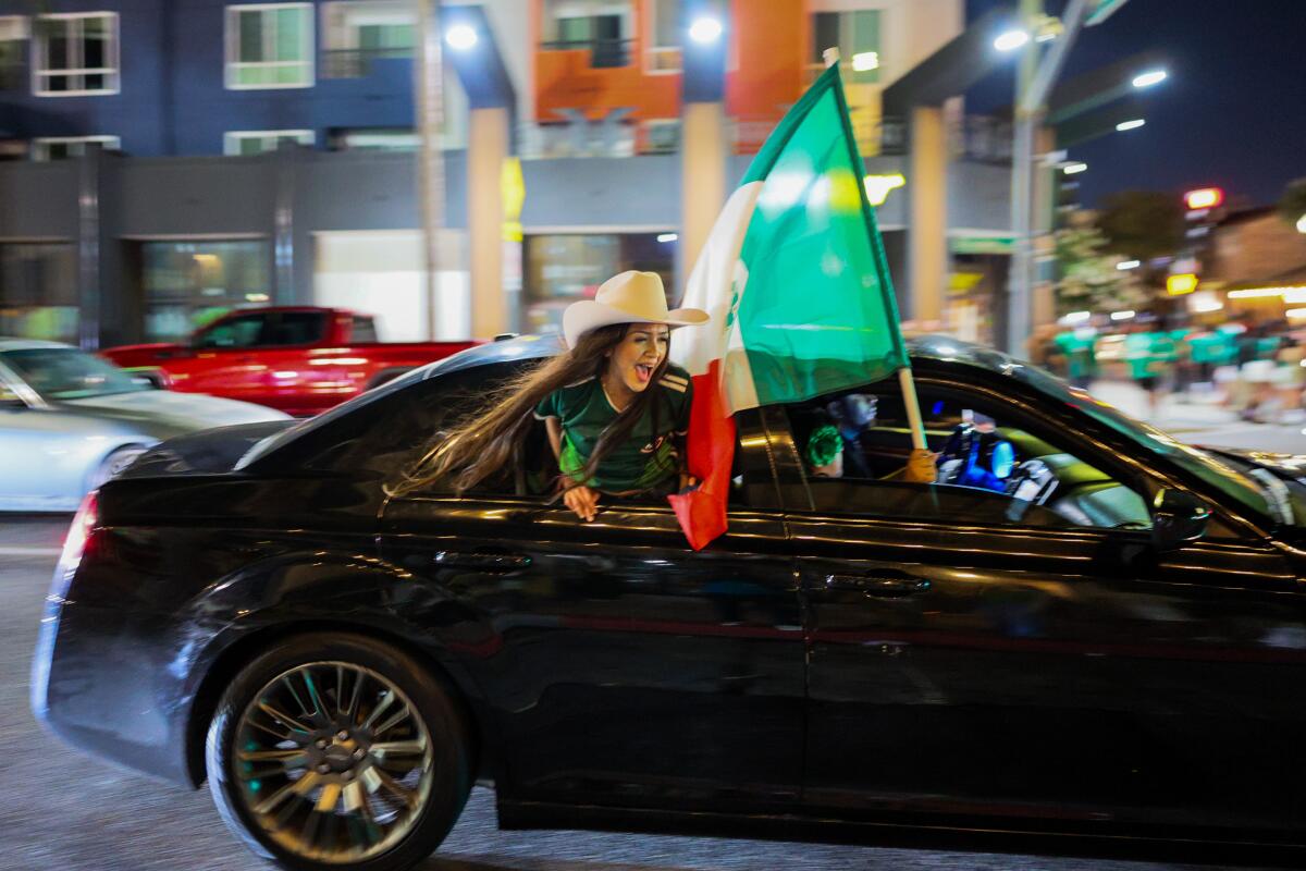 Despite Mexico's loss in its knockout round match with England on Sunday, a Mexico fan cheers in downtown Santa Ana.