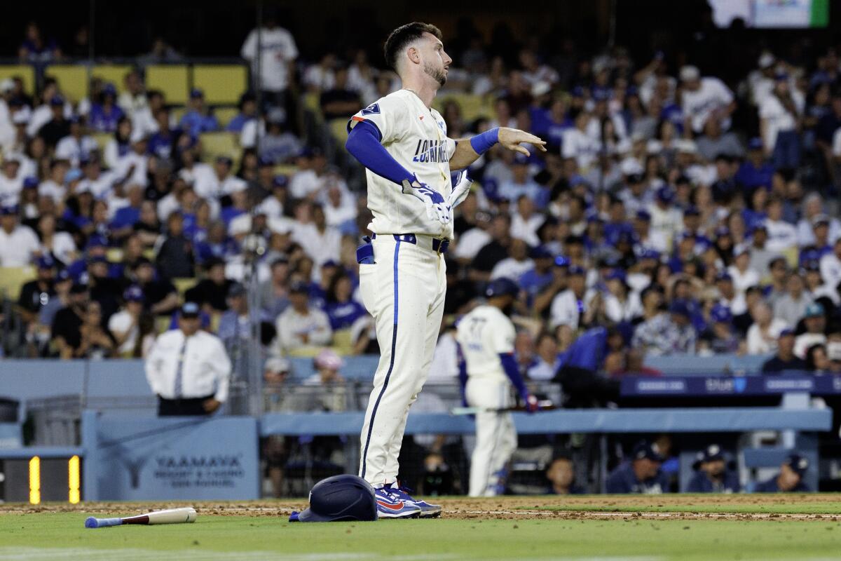 Dodgers' Kyle Tucker takes off his batting gloves after lining out with two runners on base.