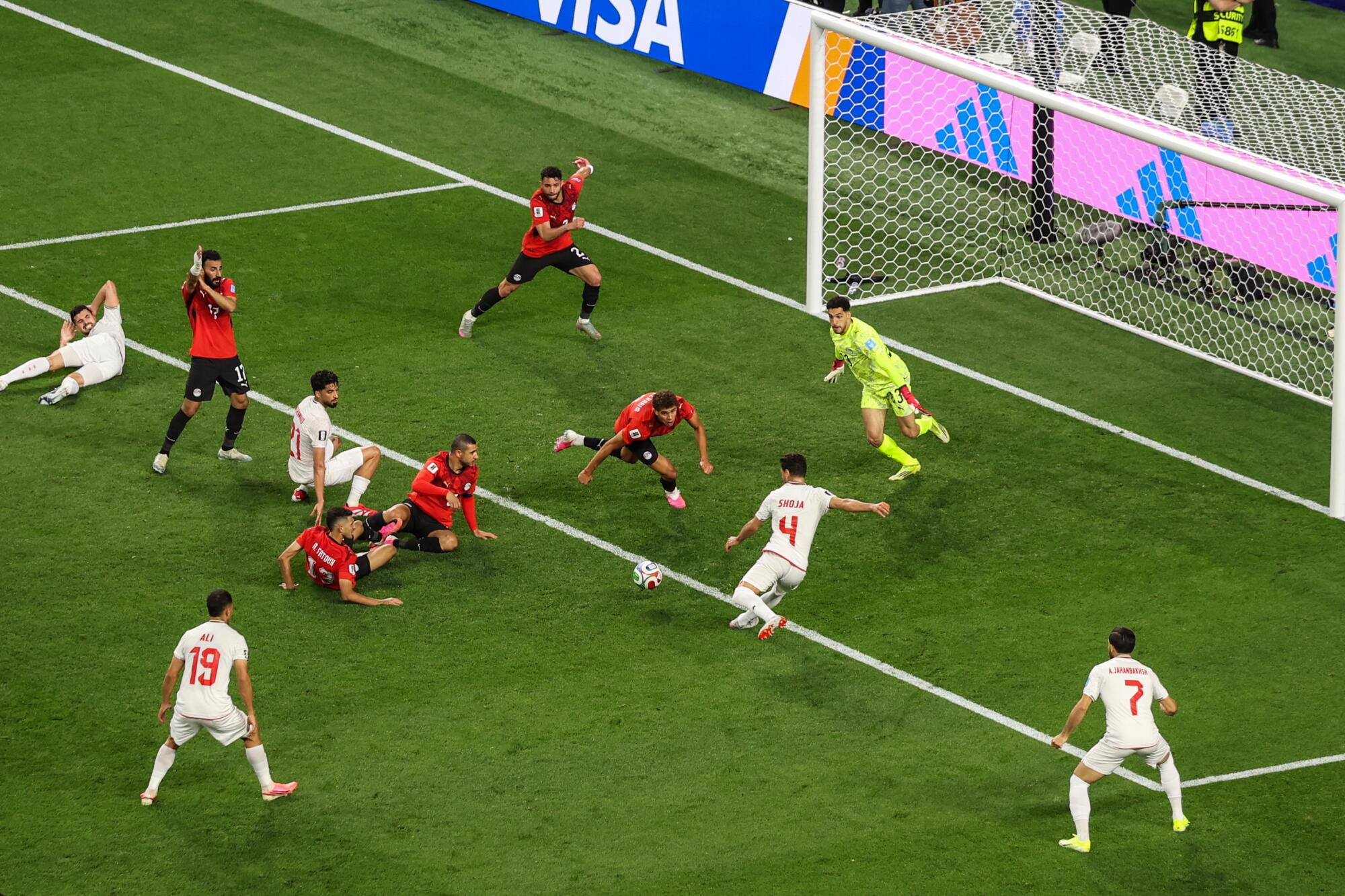 Iran's Shoja Khalilzadeh shoots past Egypt's Mostafa Shobeir, but the goal was overturned after VAR review. 