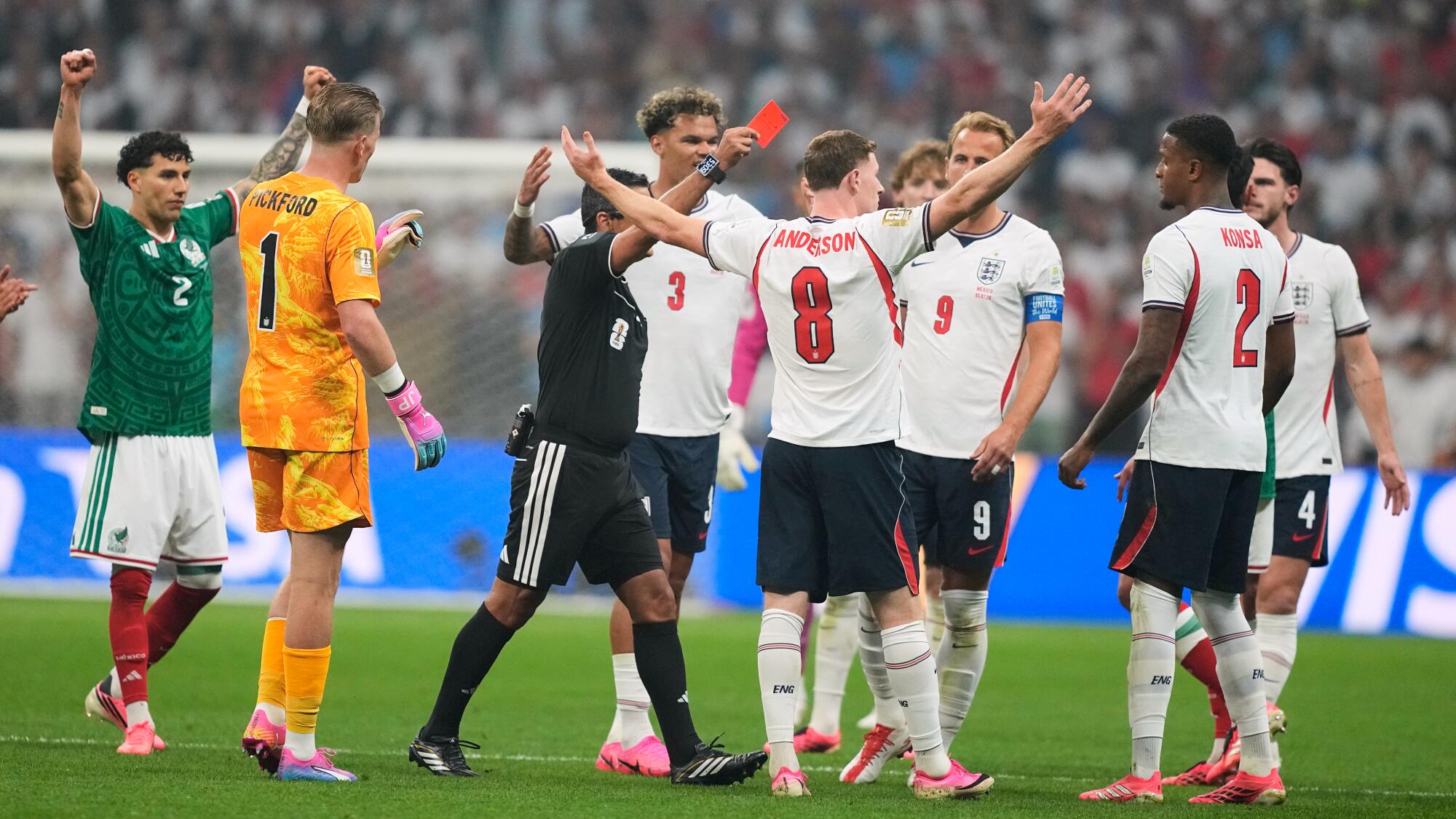 England players react as referee Alireza Faghani shows a red card to England's Jarell Quansah during a World Cup match.