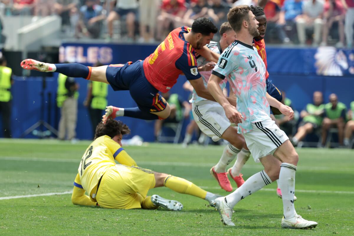 Spain midfielder Mikel Merino scores off a header in front of Belgium goalkeeper Senne Lammens.