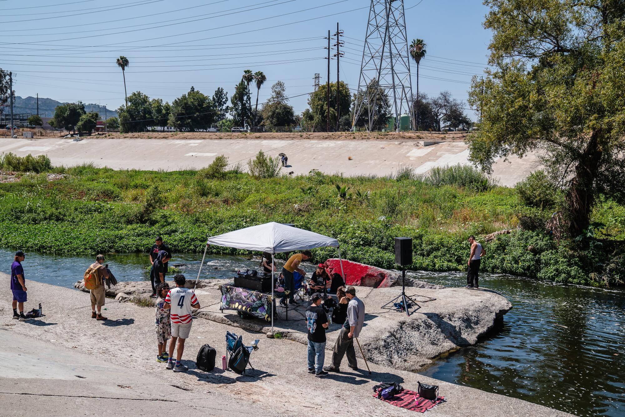 People listen to a DJ during a set at the Los Angeles River in Los Angeles.