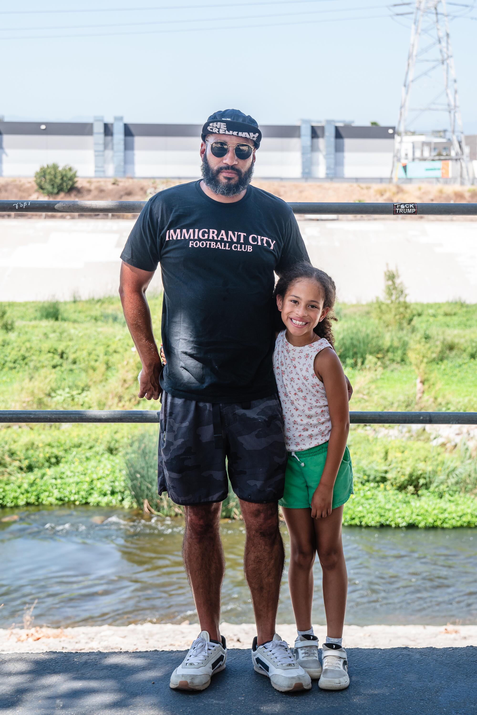 Charles Kelley with his daughter Zirah Kelley pose along the L.A. River bike path near the River Solstice Festival.