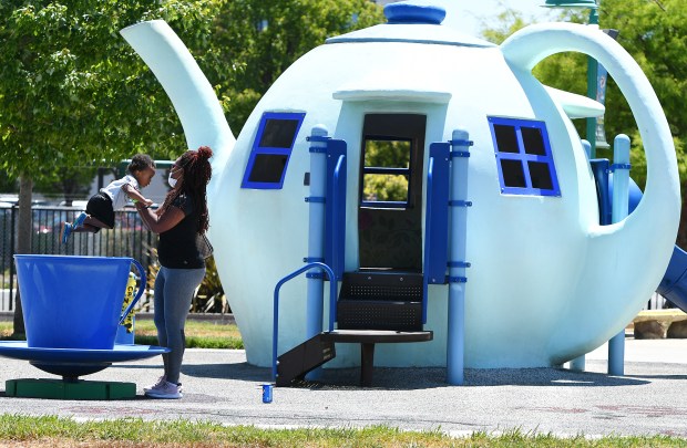 Sharee Acosta lifts her 19-month-old son Jibril out of a teacup in front of the iconic teapot at Children's Wonderland park in Vallejo in 2021. (Chris Riley/Times-Herald)