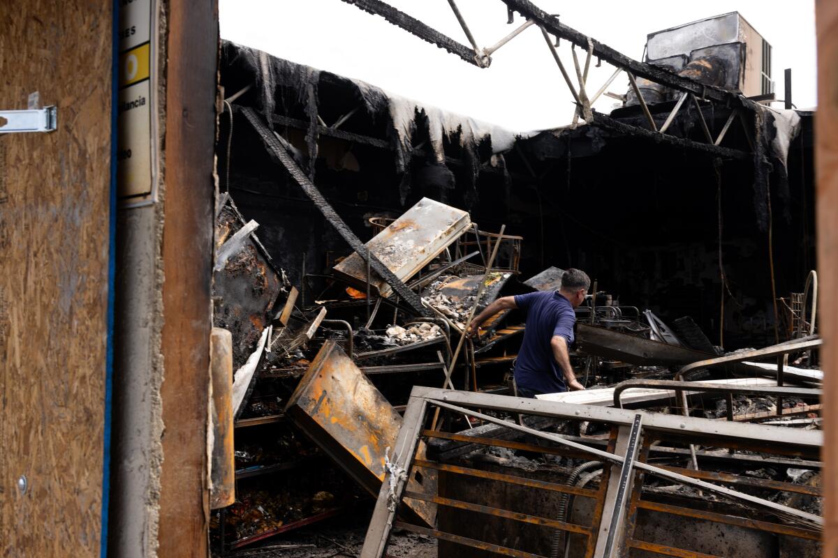 Owner Genaro Salcedo walks through fire destruction.