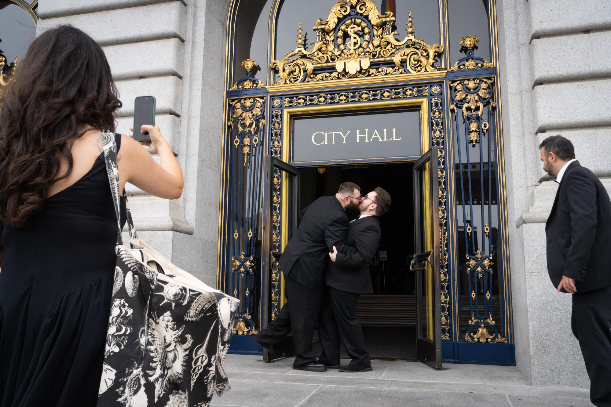 A couple kisses at City Hall.