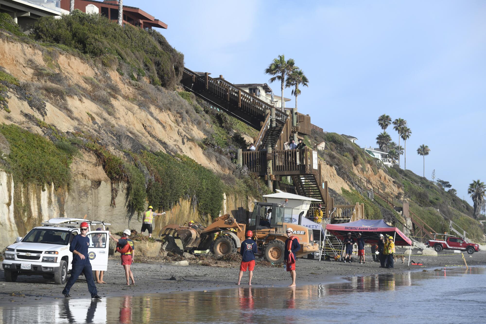 Search and rescue personnel work at the site of a cliff collapse at a beach 