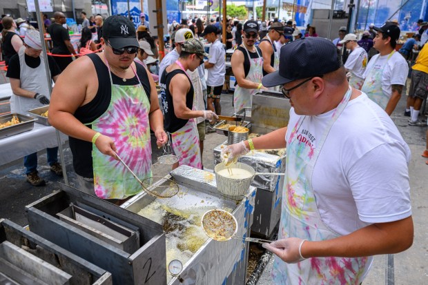 Alex Tsukahara, left, and Brett Low work the hot oil machine while making tempura during the San Jose Obon Festival in San Jose, Calif., on Saturday, July 11, 2026. (Jose Carlos Fajardo/Bay Area News Group)