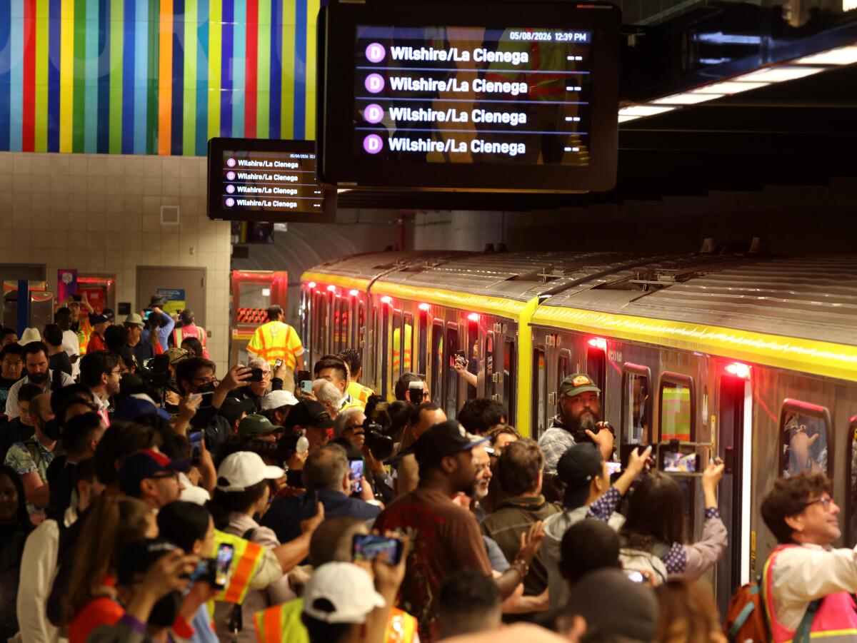 Passengers wait to board the first train to arrive at the Metro D Line at the Wilshire/Fairfax Station 