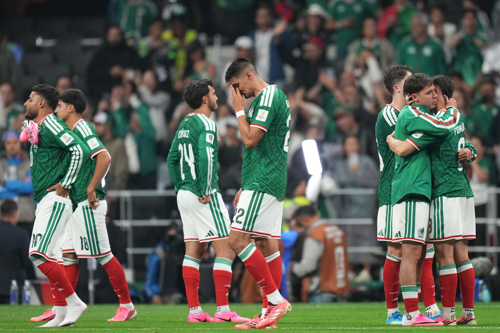 Mexico players cry and embrace after they lost to England at Azteca Stadium Sunday, ending their World Cup run.