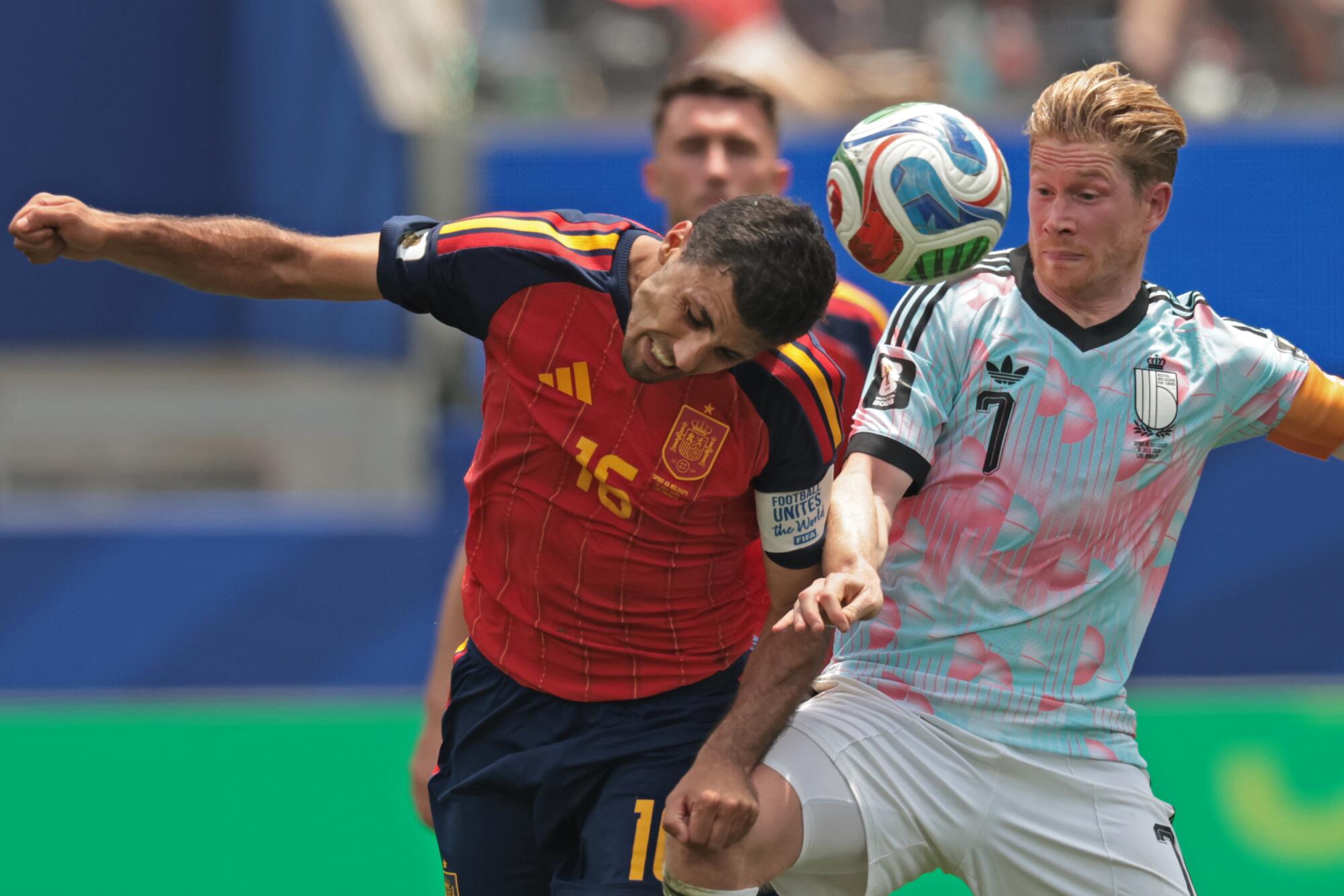 Spain midfielder Rodri, left, and Belgium midfielder Kevin De Bruyne battle for the ball.