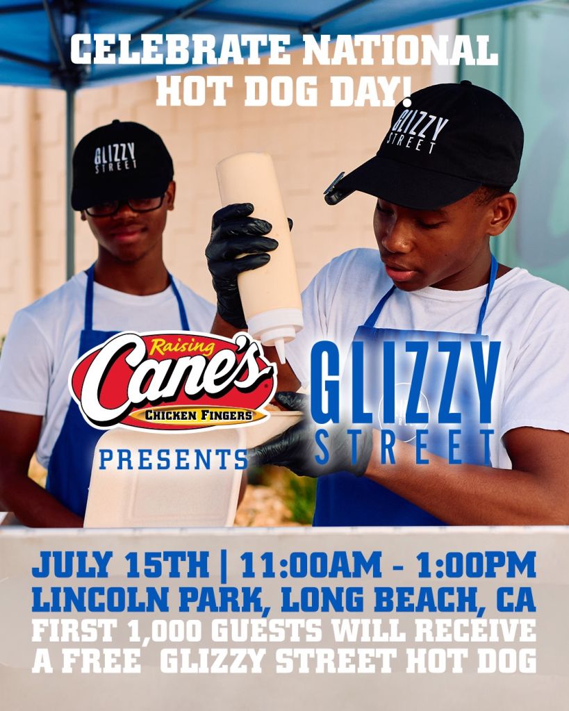 Two young men wearing Glizzy Street hats and aprons, holding Raising Cane's Chicken Fingers products, in front of a banner advertising "National Hot Dog Day" event at Lincoln Park, Long Beach, CA.