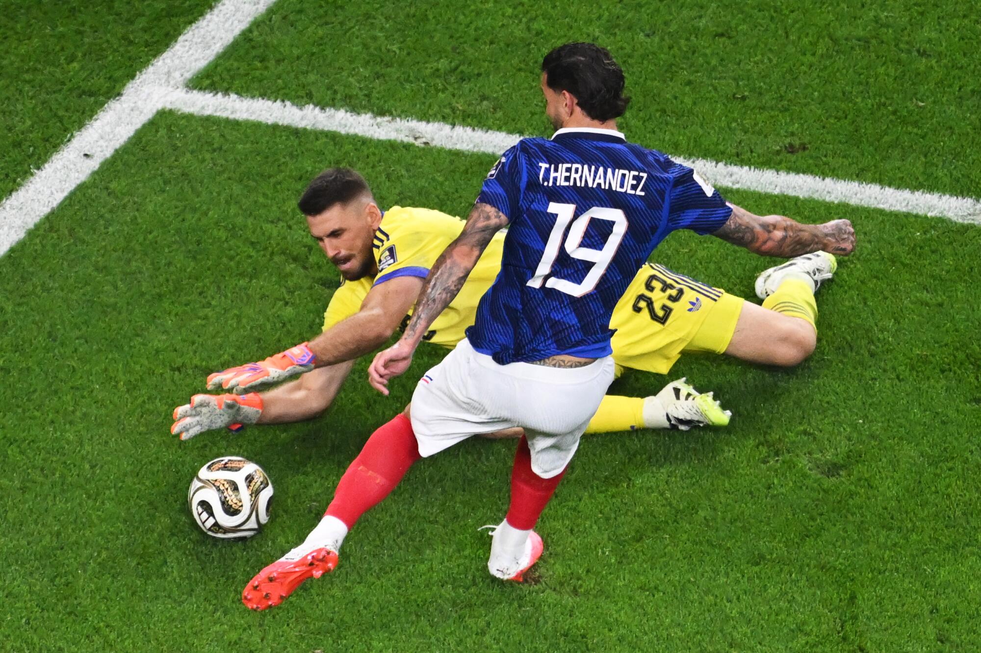 Spain goalkeeper Unai Simon makes a save in front of France's Theo Hernandez during a World Cup semifinal.