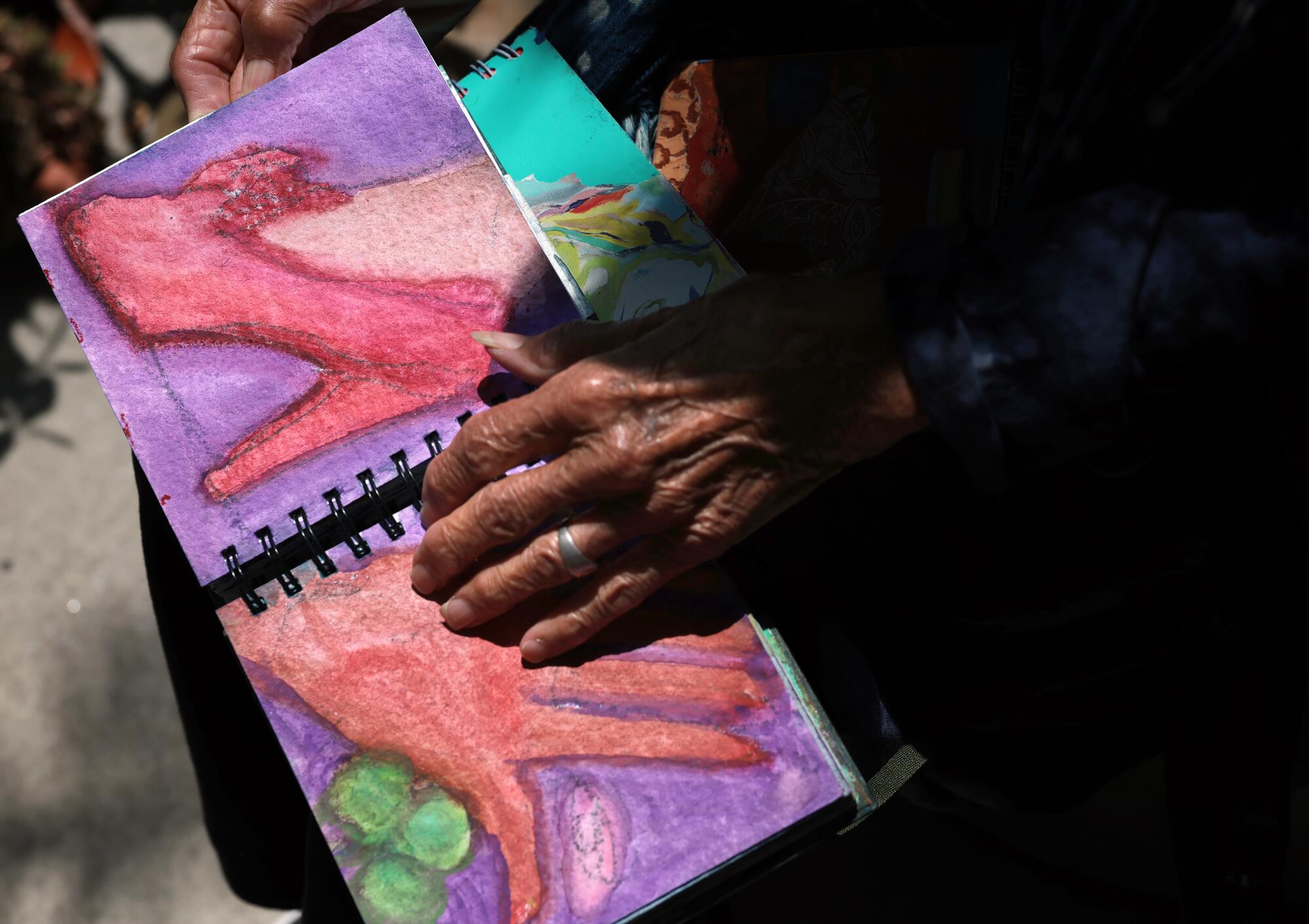 A woman's hand on a watercolor.