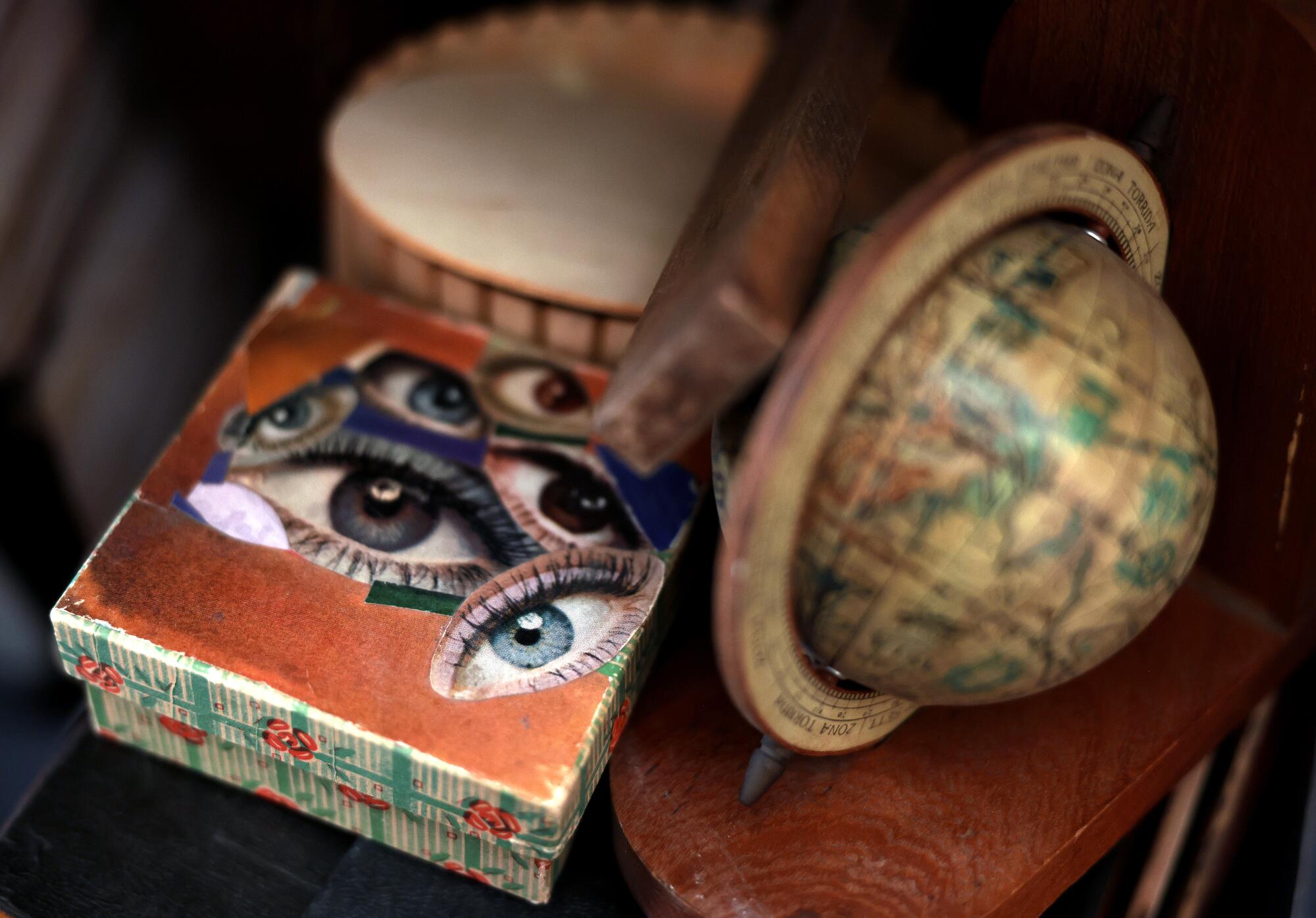 A old globe and a box covered in collage.