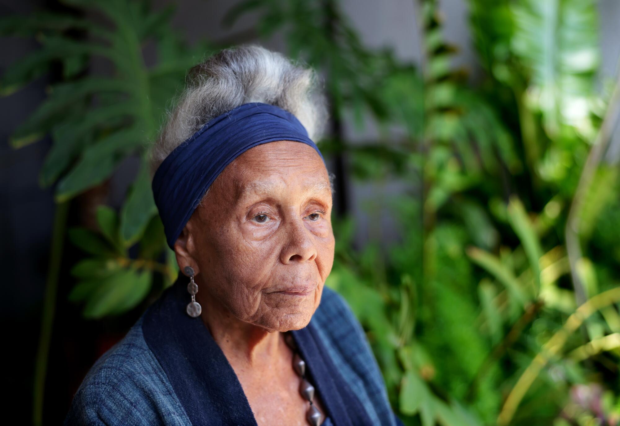 A portrait of a woman wearing a blue head scarf.