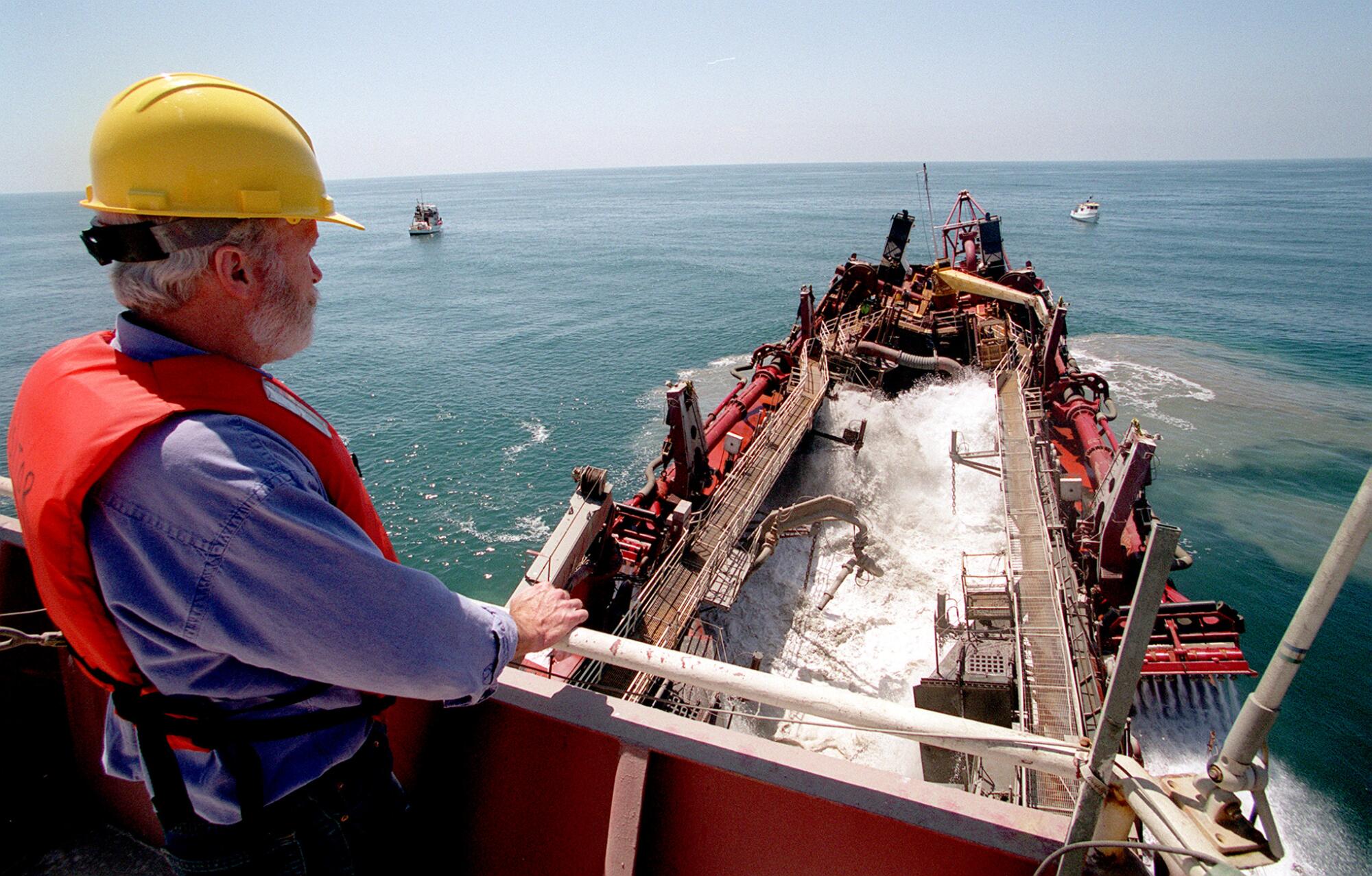 EPA project manager Fred Schauffler watches as the first loads of sand are dropped over a giant DDT deposit, Aug. 22, 2000. 