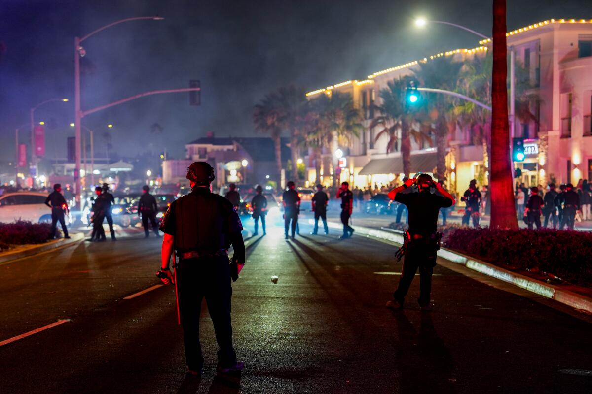 Newport Beach police form a skirmish line in an effort to control an unruly Fourth of July crowd.