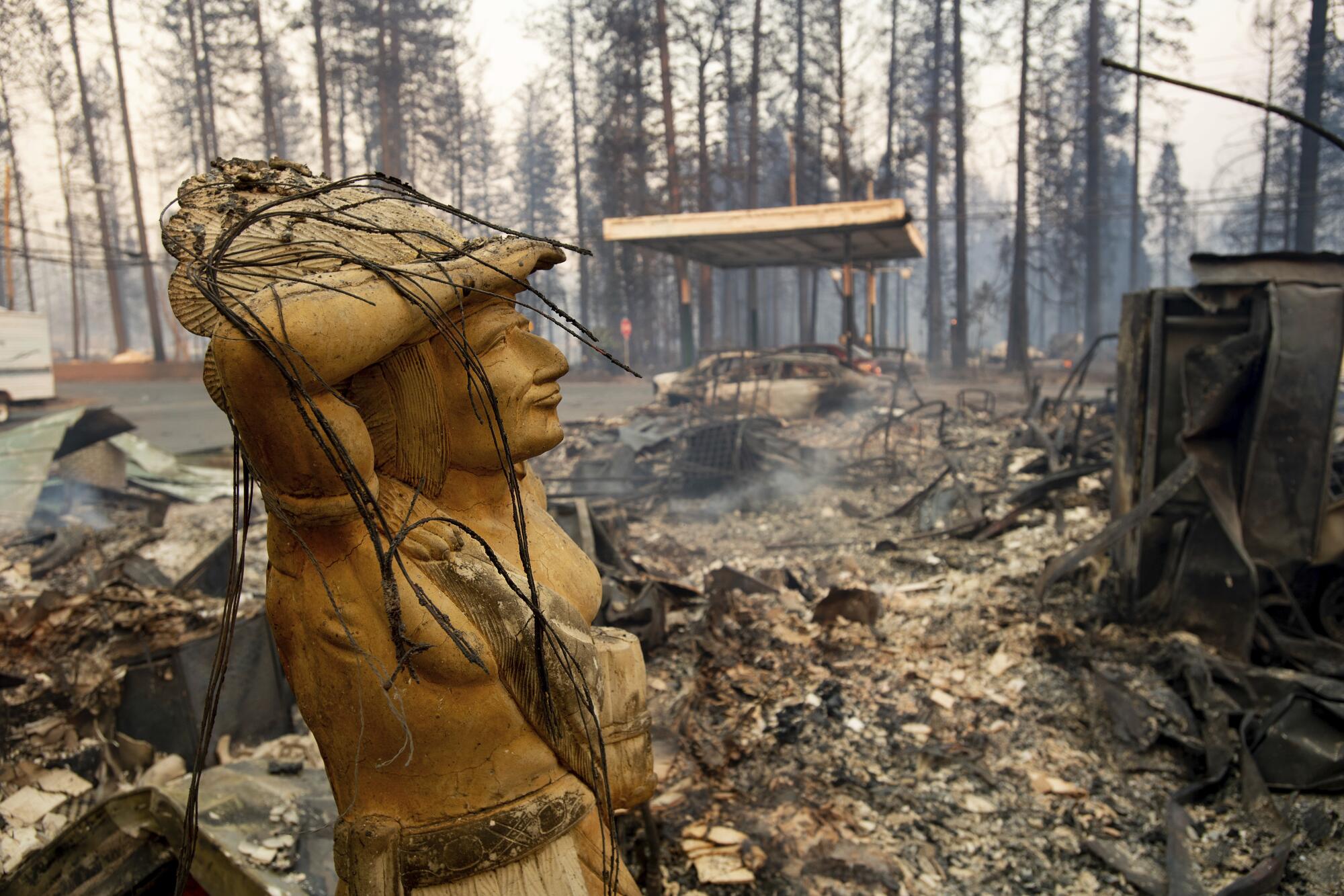 A statue rests amid a charred lot 