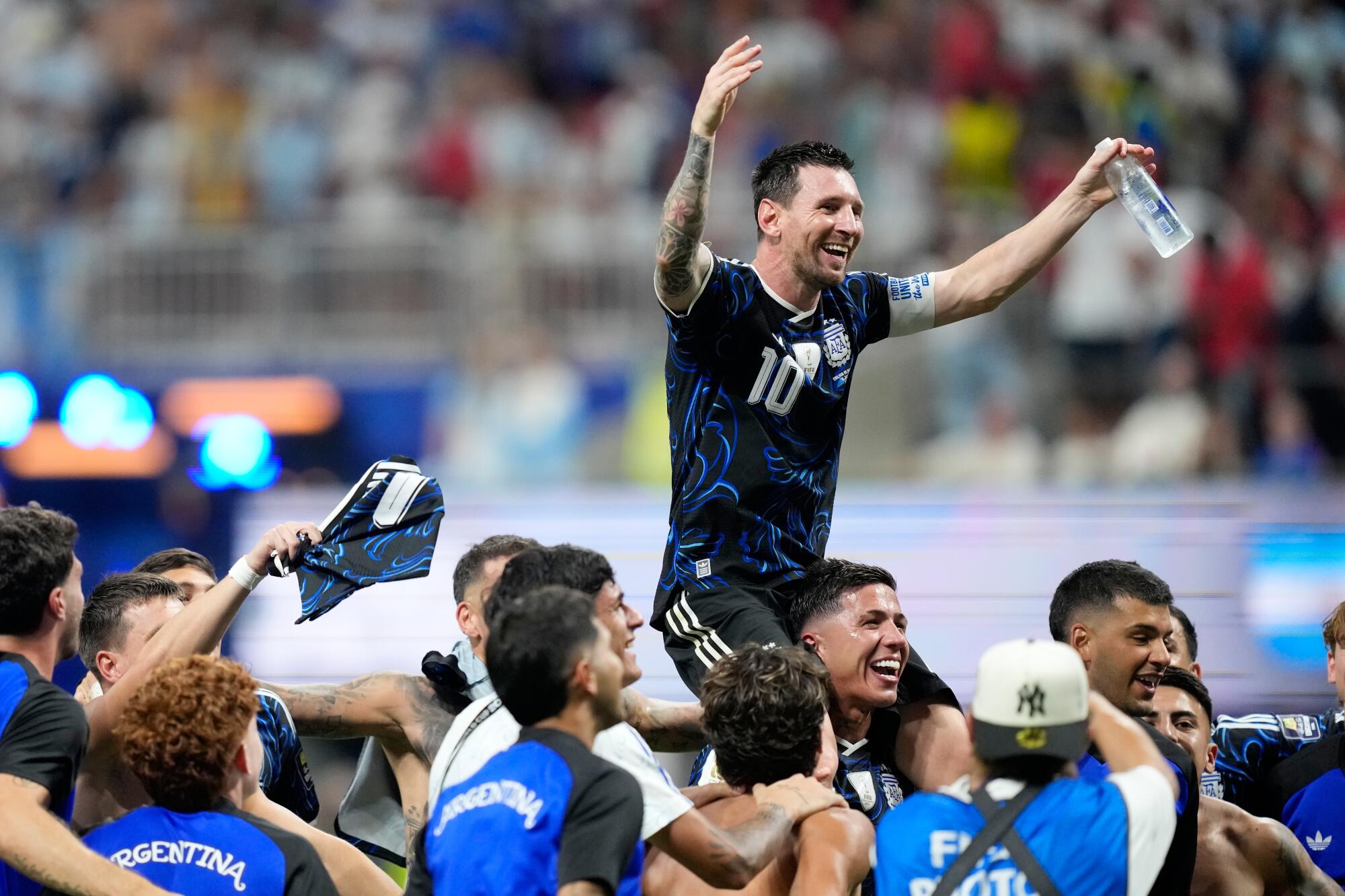 Argentina's Lionel Messi sits on the shoulders of a teammate and celebrates after beating England.