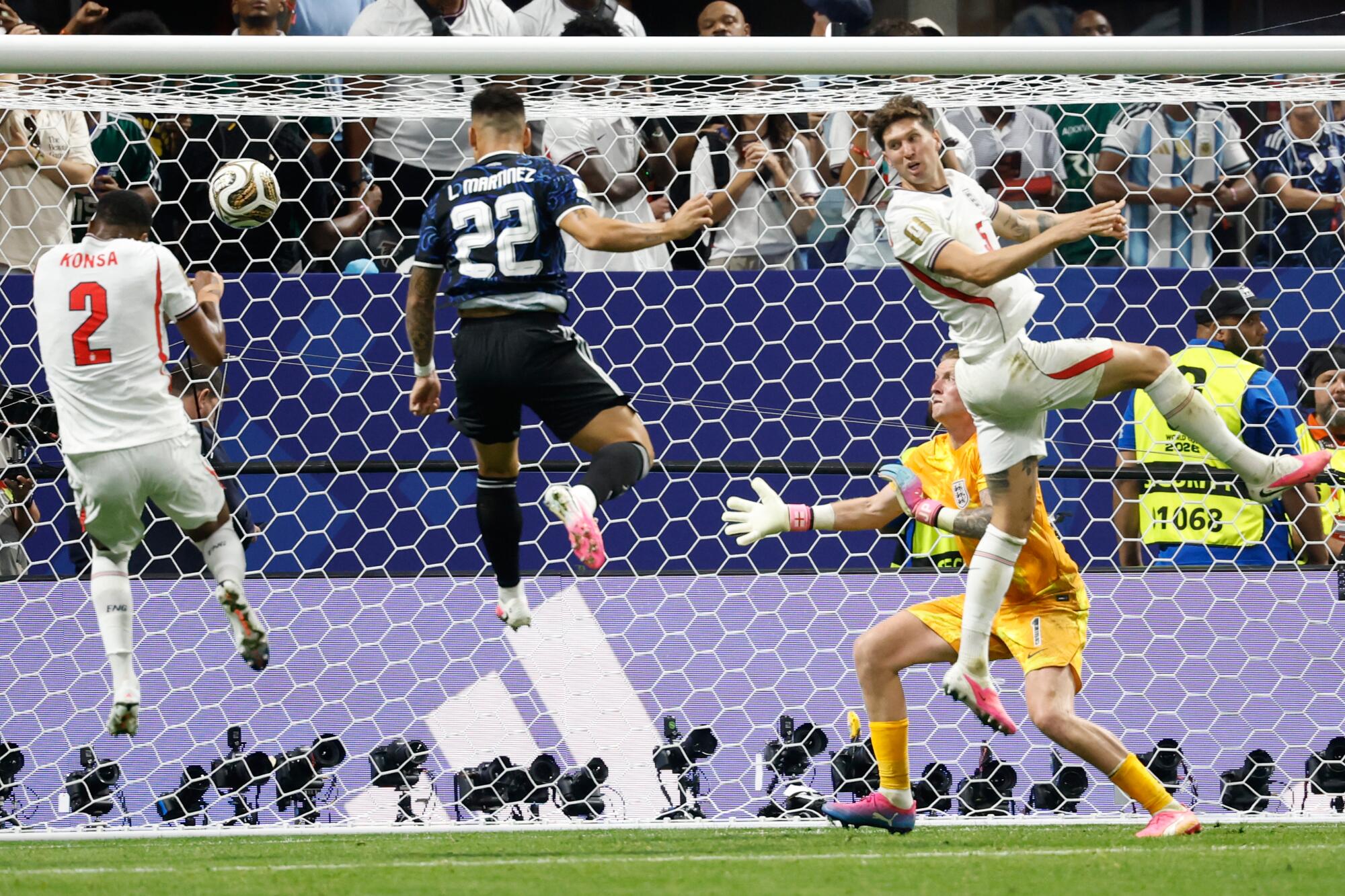Argentina's Lautaro Martinez scores in front of England goalkeeper Jordan Pickford and other English players.