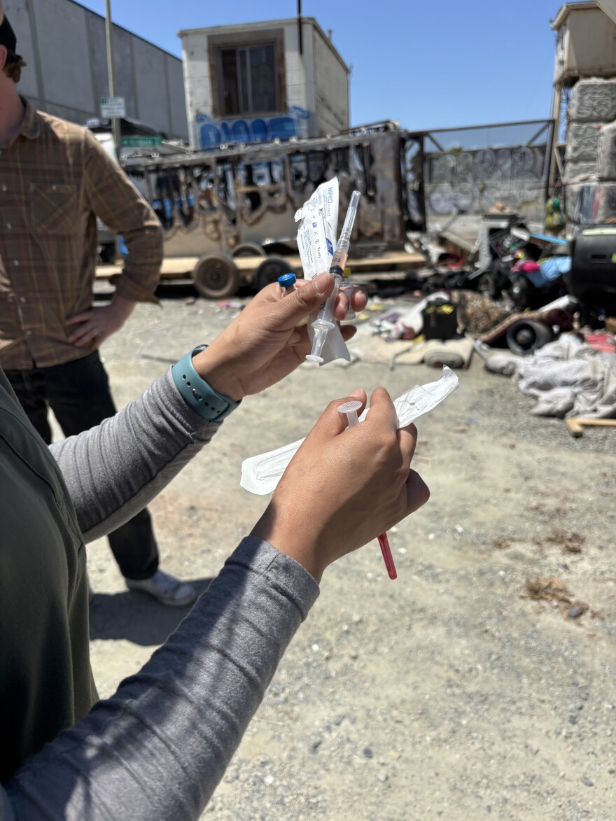 Volunteer and vet tech Jocelyn Saenz-Sanchez prepares a vaccine for I AM.
