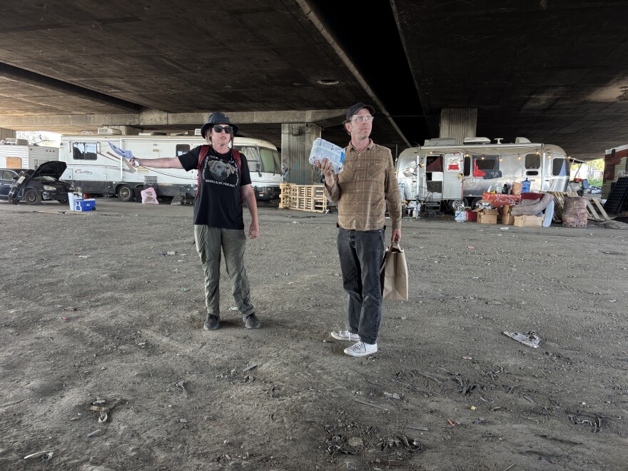 Volunteers Jen Strauss (left) and Chris Slater (right) hand out kibble near the Lake Merritt Estuary.