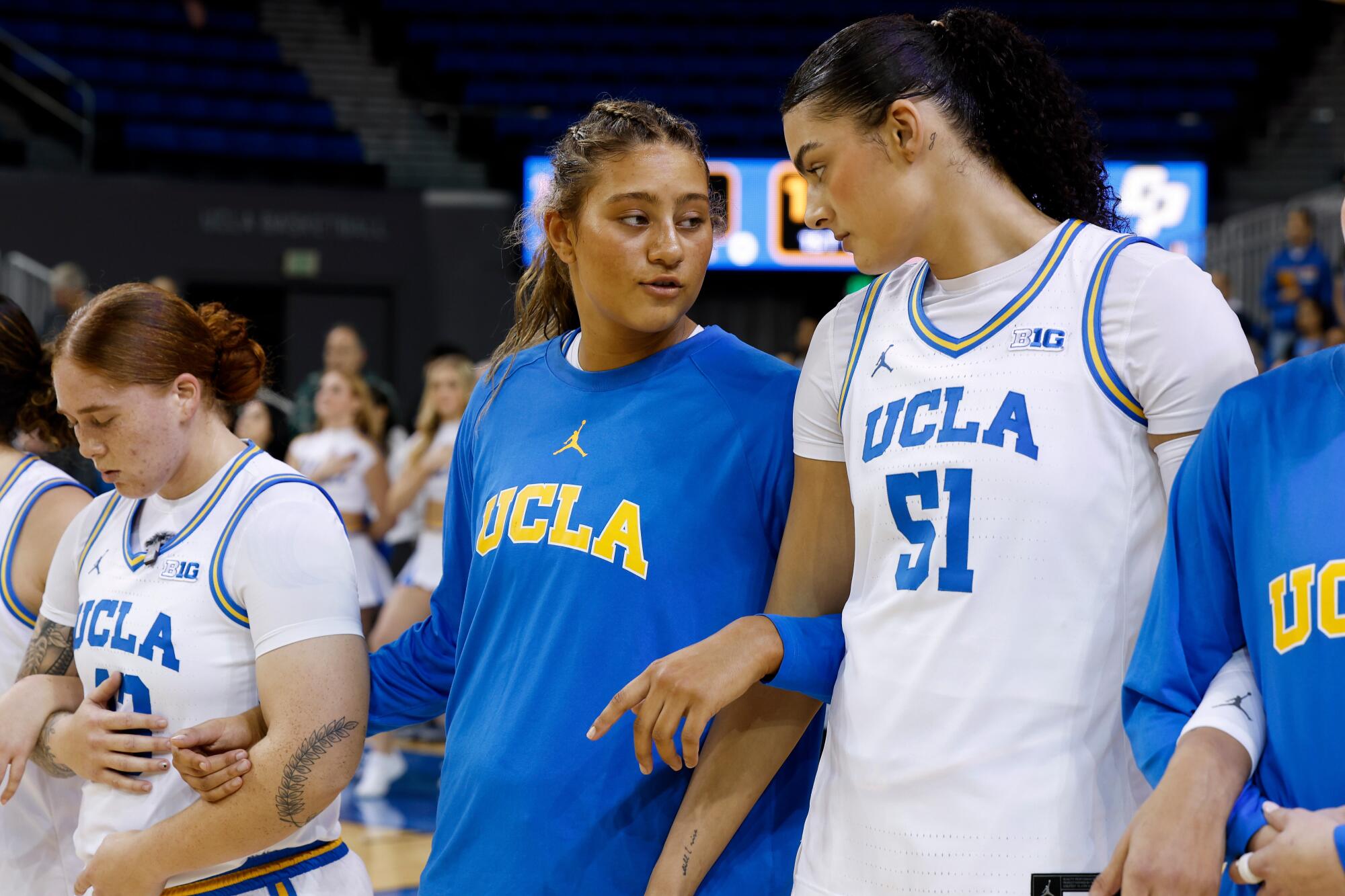 UCLA forward Sienna Betts, left, speaks to her older sister, UCLA center Lauren Betts, before a game in December.