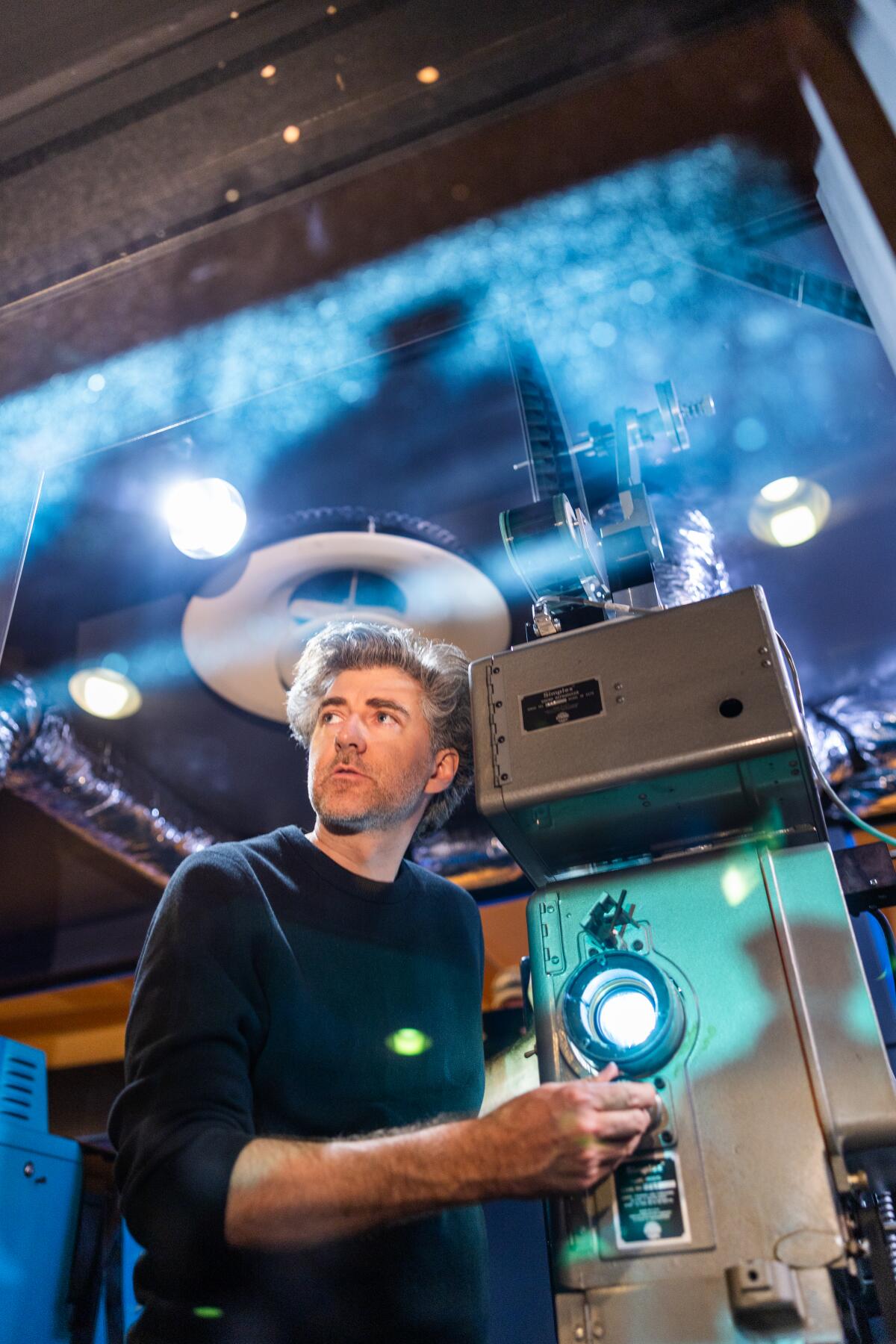 A man operates a projector.