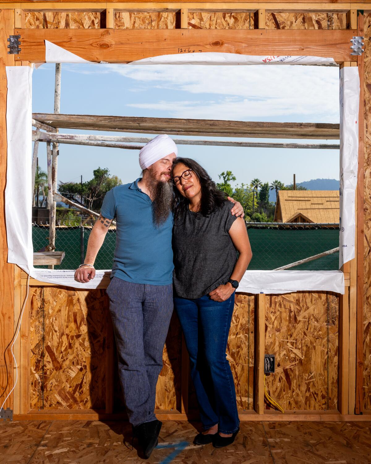Two people pose in a half built house