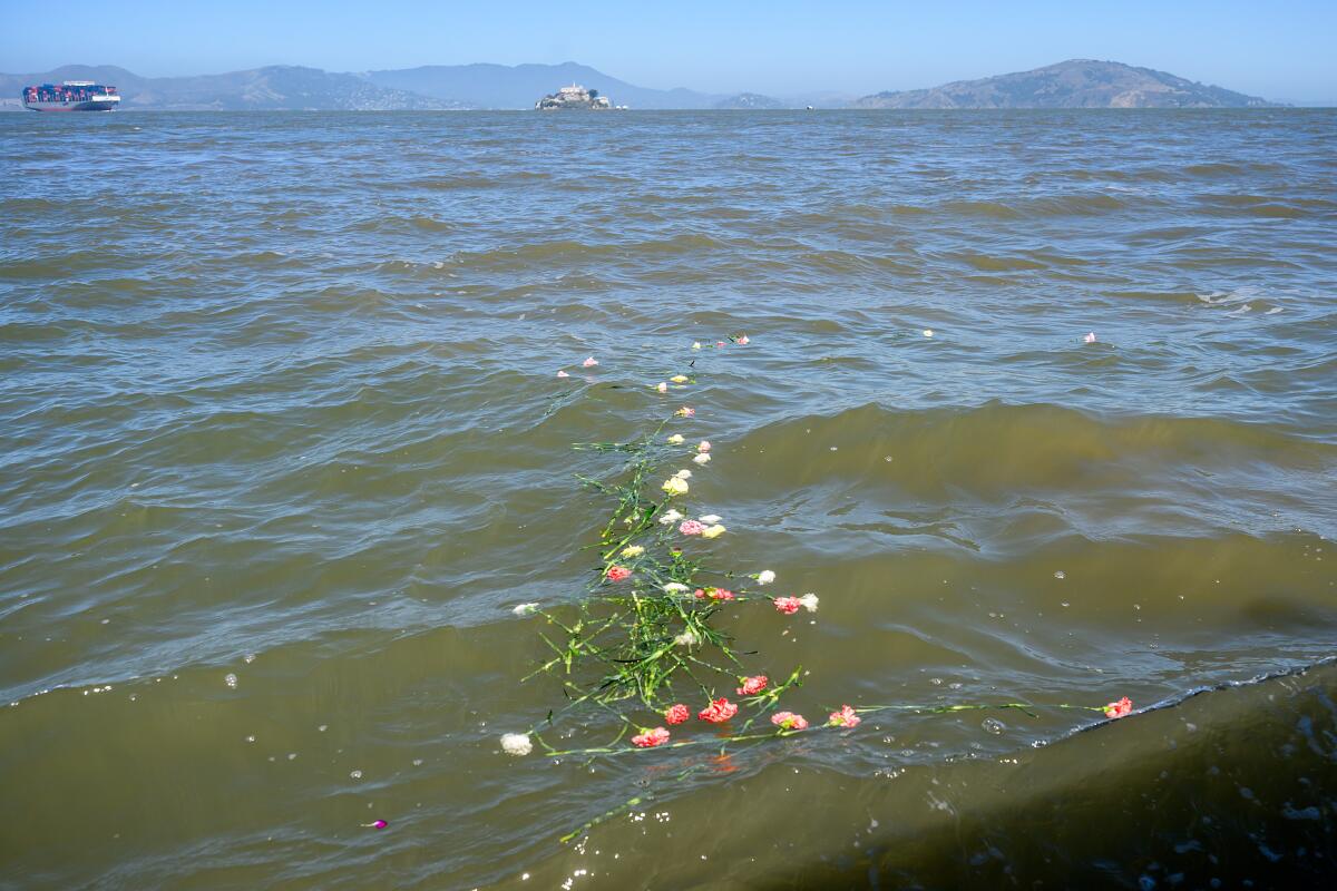 With Alcatraz Island in the background, flowers float on the San Francisco Bay.