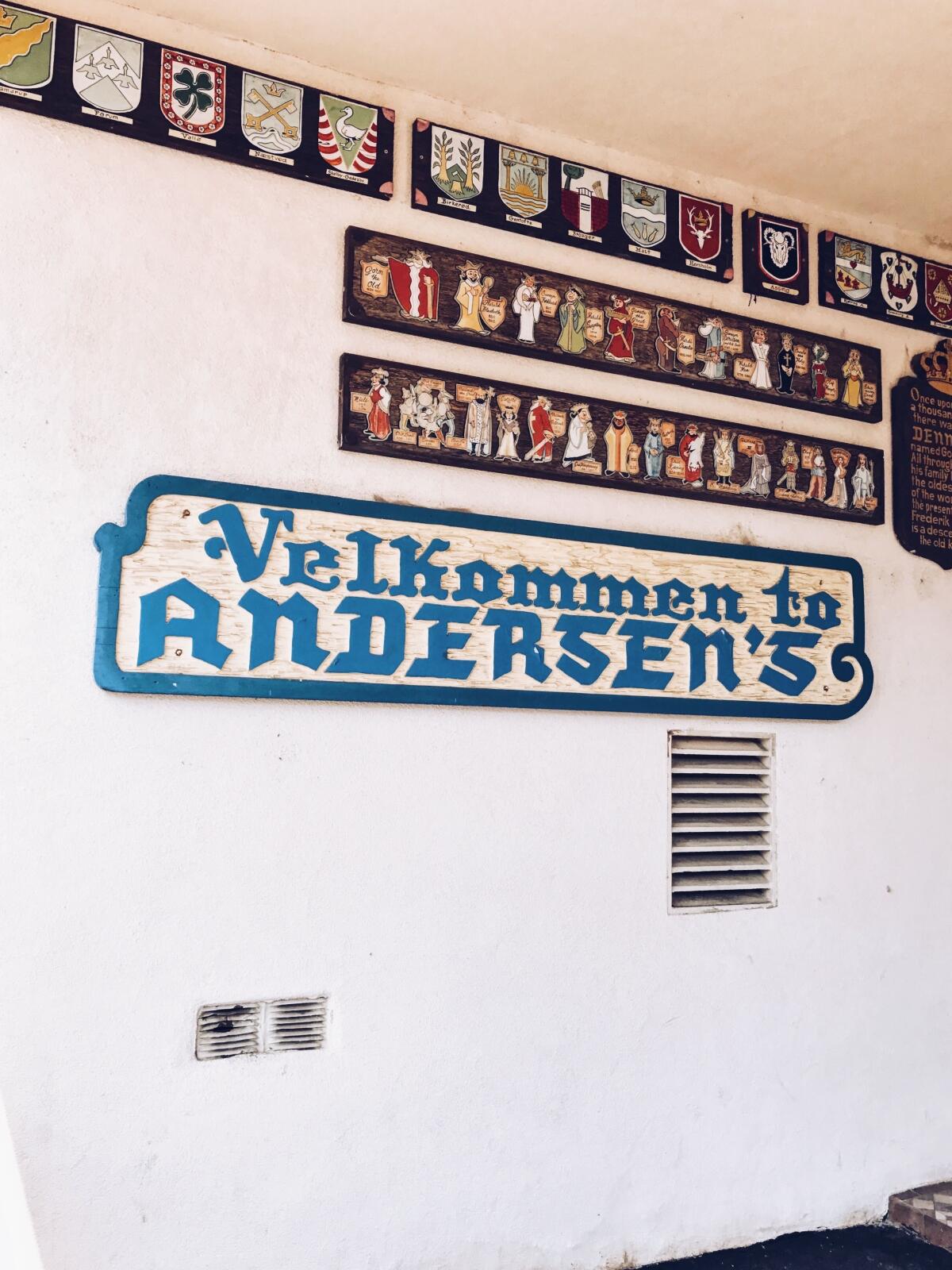 Carved wooden signage "Velkommen to Andersen's" in blue and white at the Buellton location of Pea Soup Andersen's.