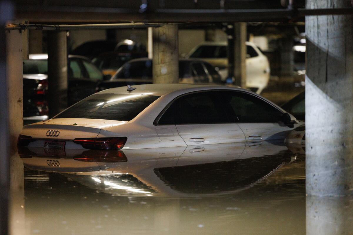 Cars damaged by a water main break sit in a parking lot.