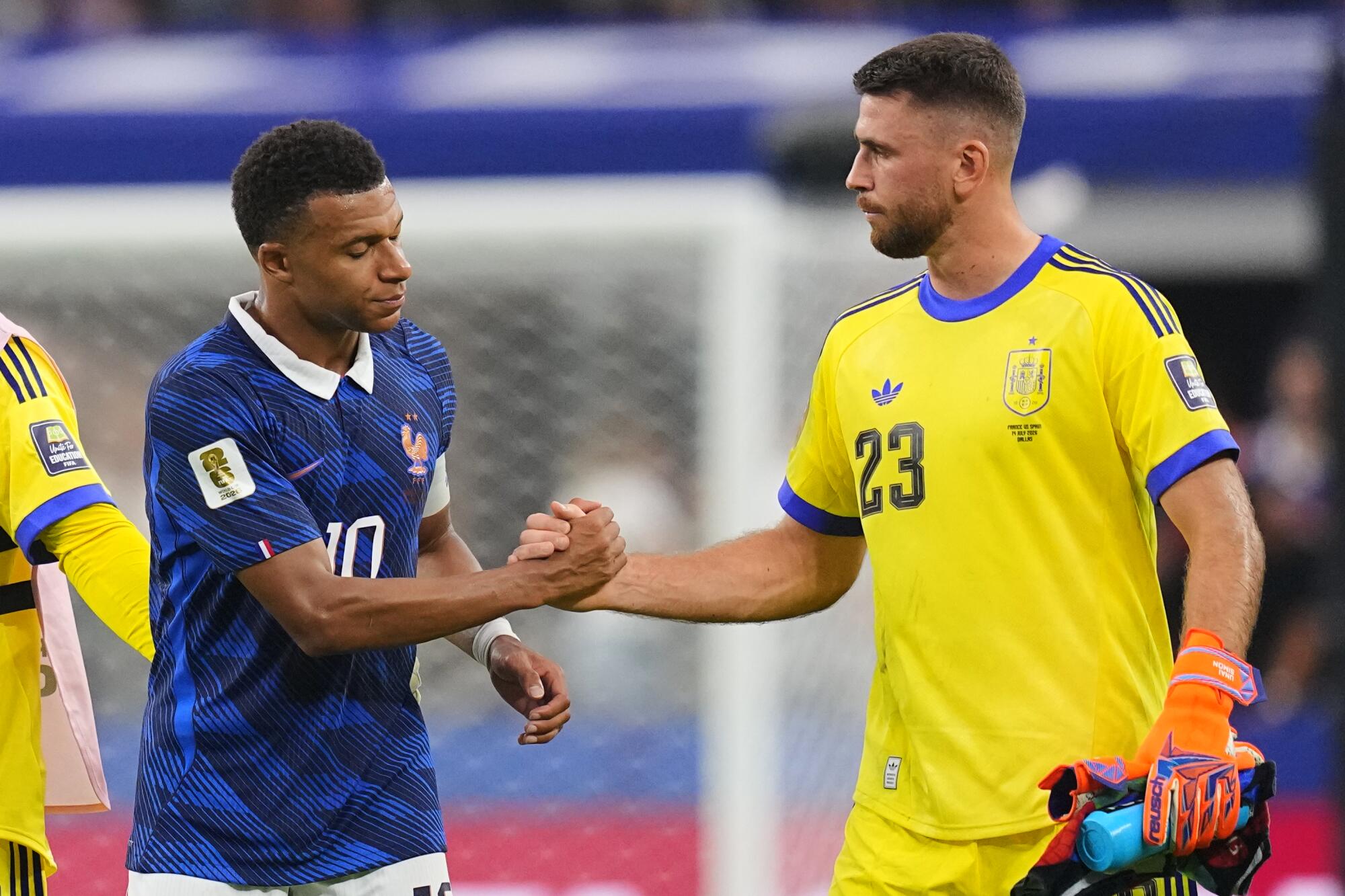 France's Kylian Mbappe (left) and Spain goalkeeper Unai Simon shake hands after the World Cup semifinal game Tuesday.